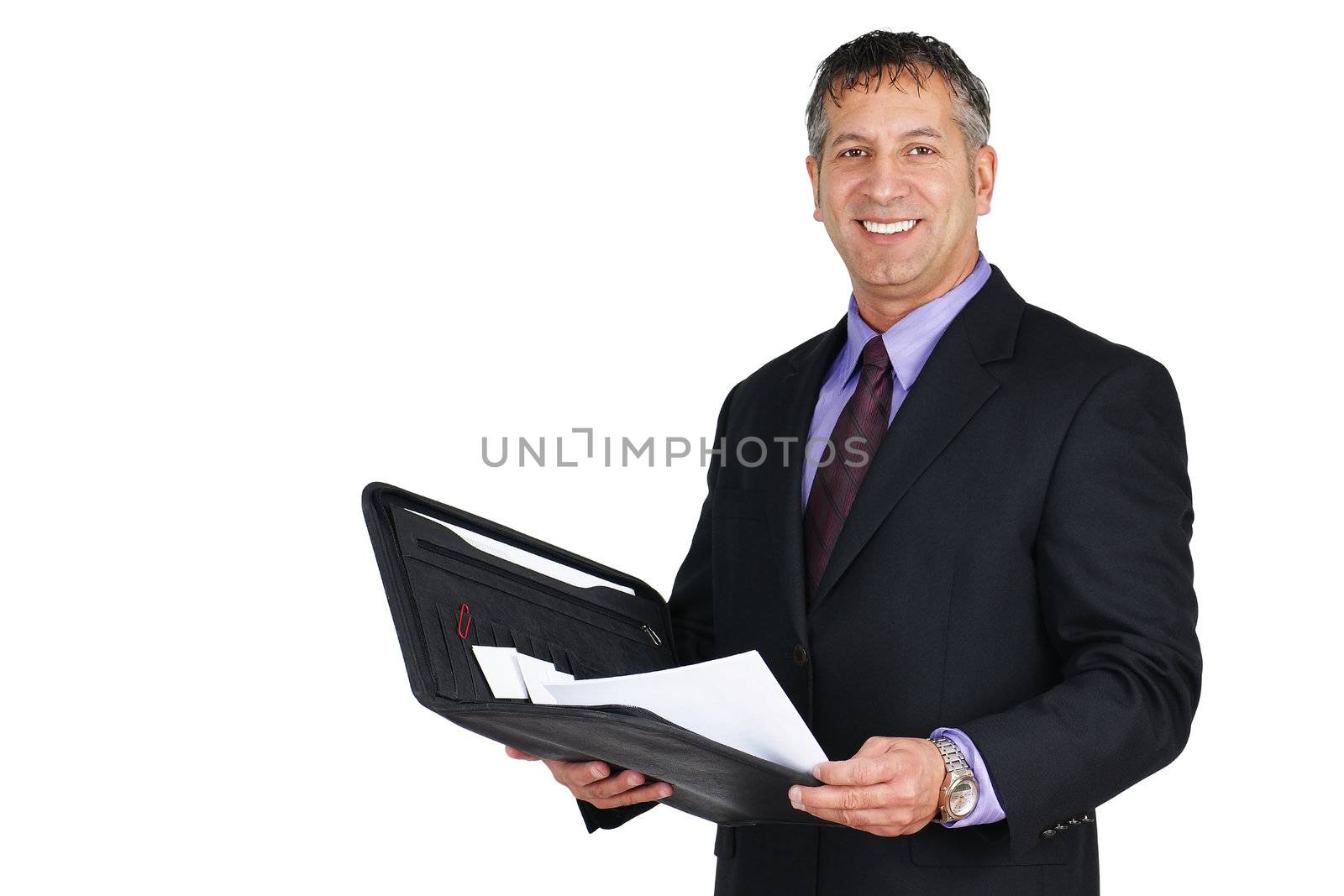 Man in suit and tie, holding paperwork and smiling, can be boss or management employee.