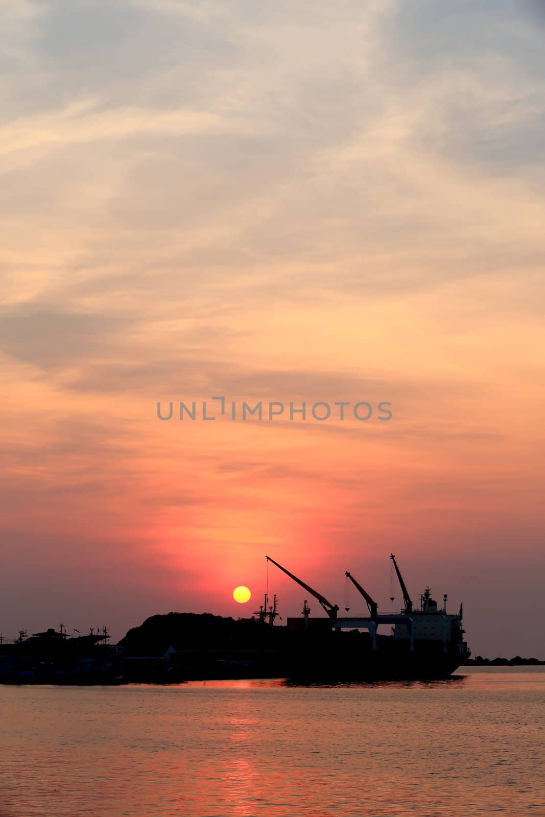 Cargo ship in the harbor at sunset
