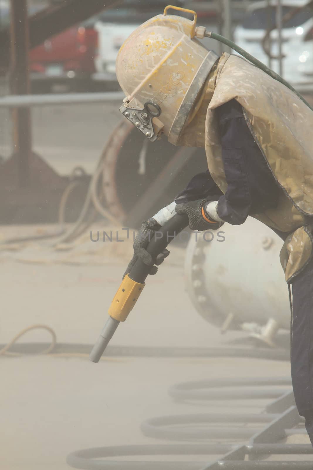 Sandblasting of metal structures at construction site by rufous