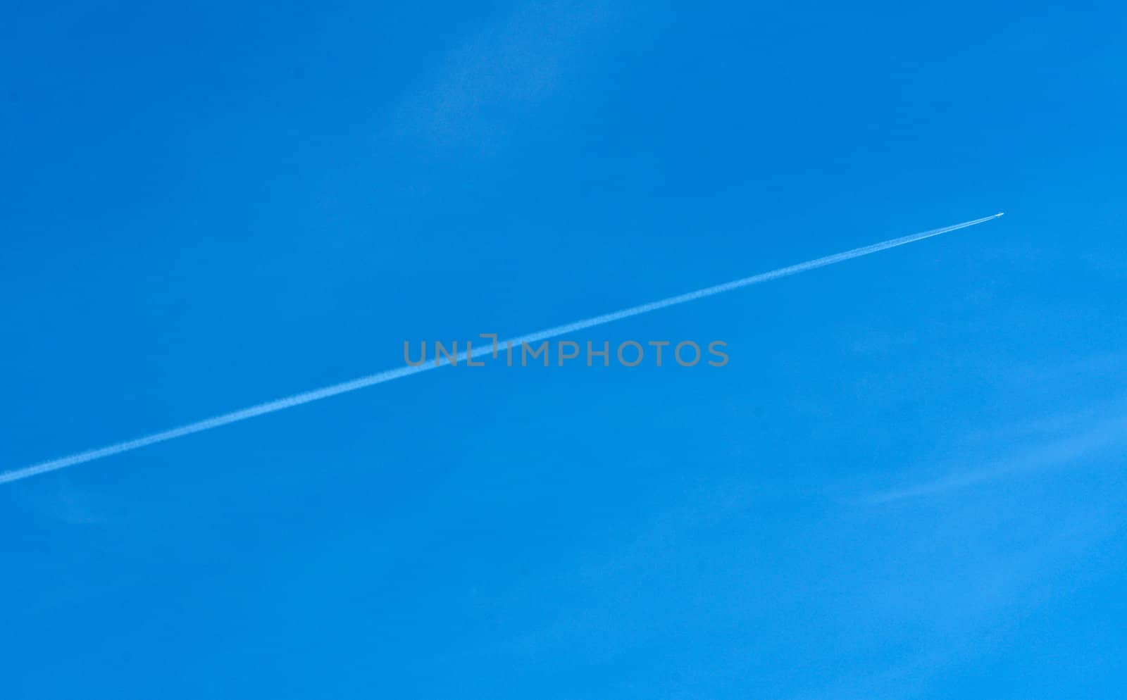 Diagonal airplane trace on a clear blue sky