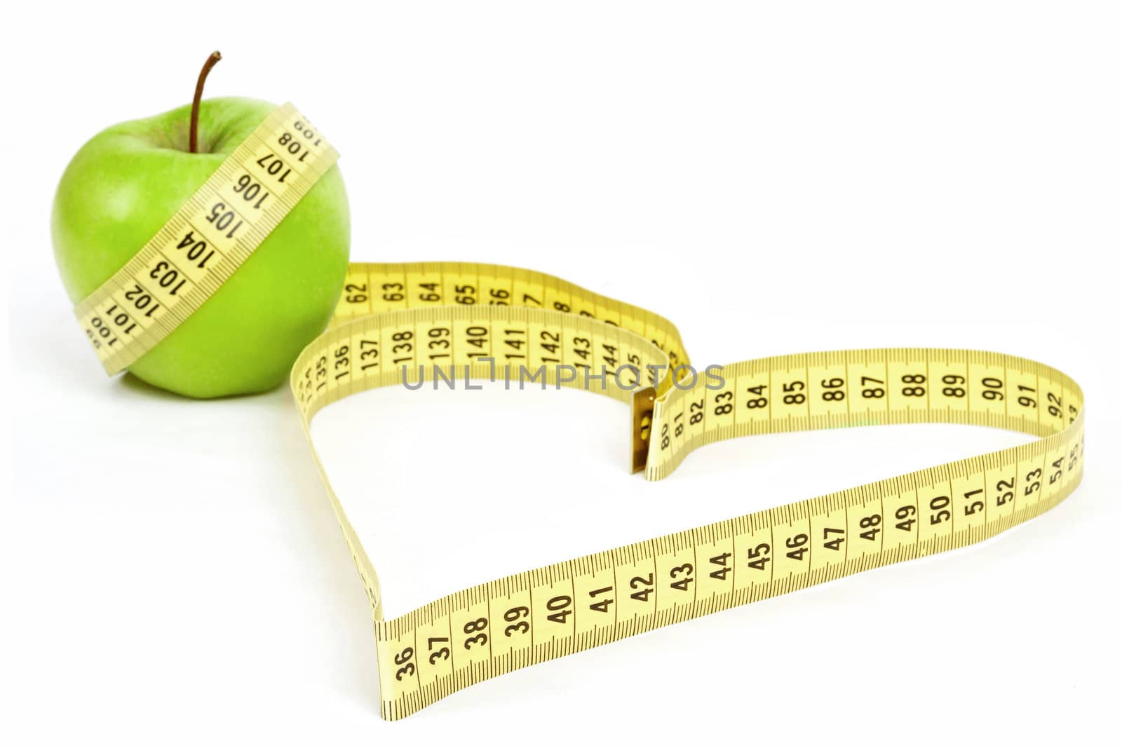 Tape measure heart shape and green apple  - health, weight concept 
