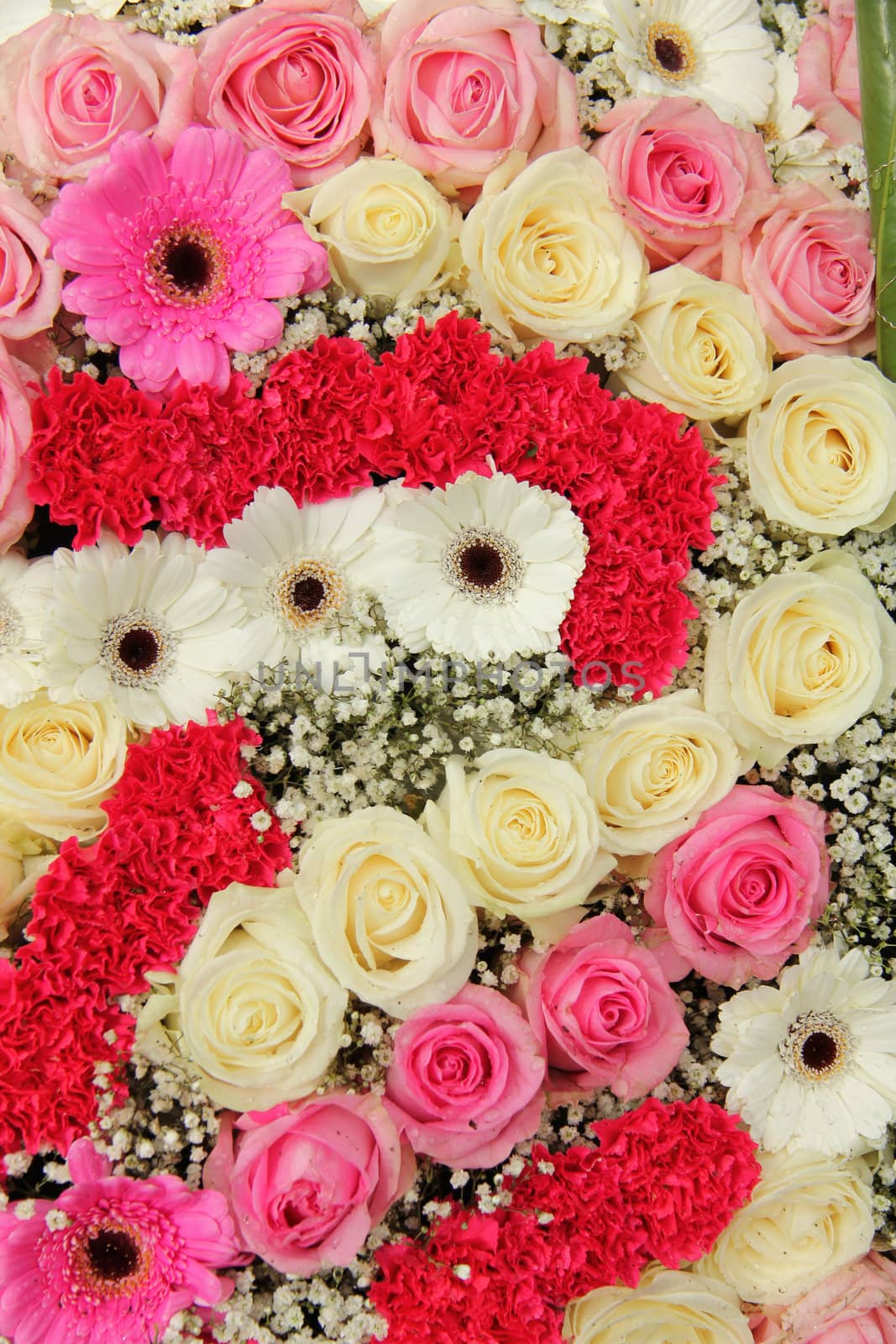 pink and white roses, together with carnations and gerberas in a wedding centerpiece