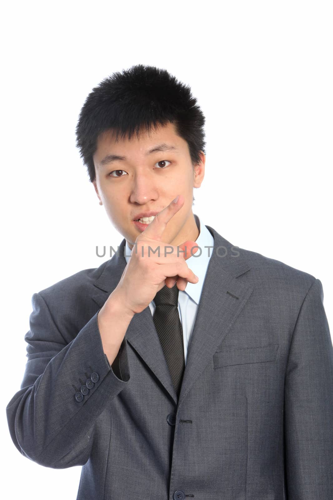 Serious asian businessman pointing upward isolated on white