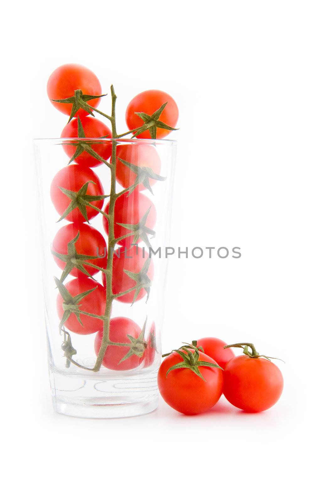 Small cocktail tomatoes in a glass isolated on white