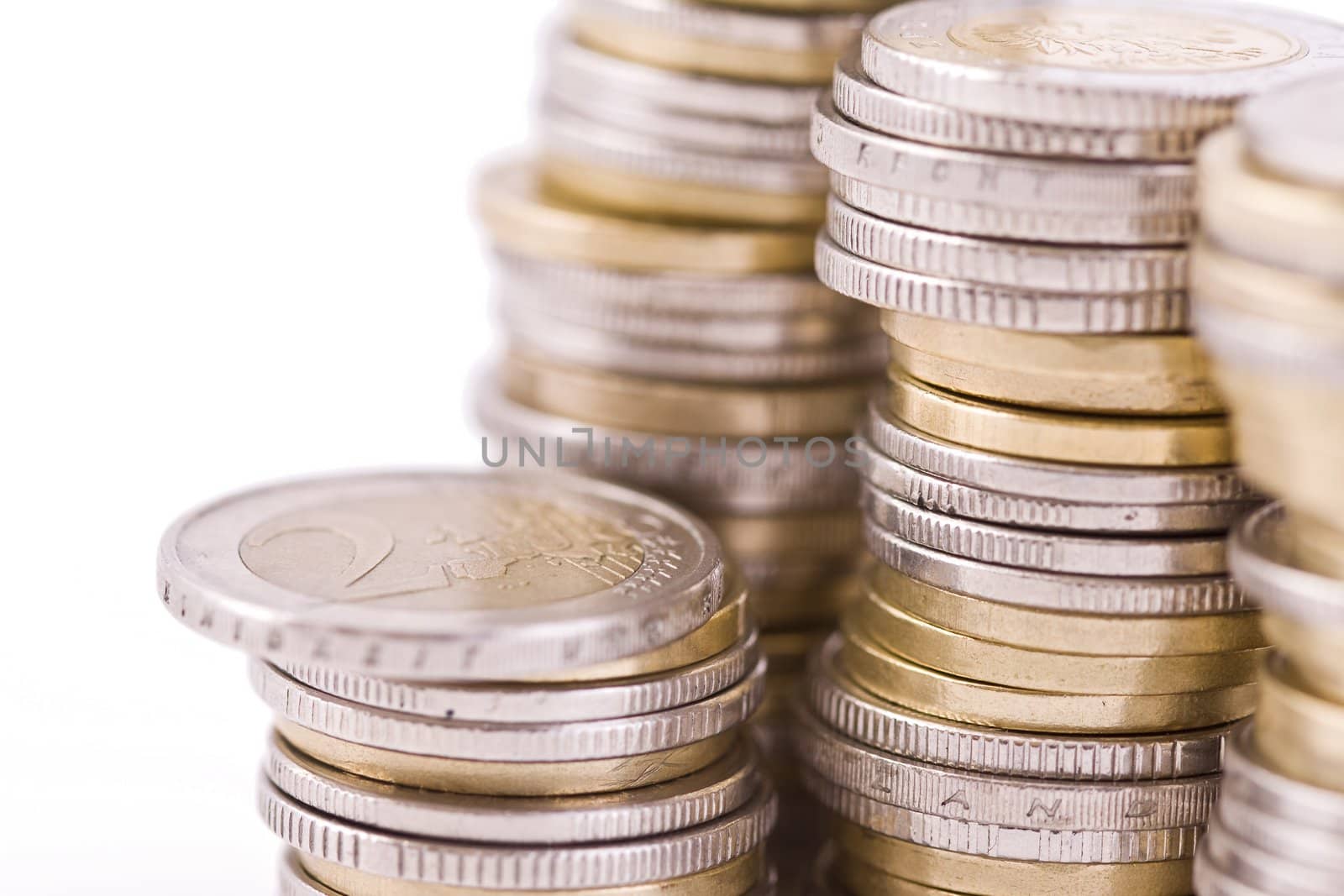 Piles of shiny coins isolated on white, defocused money closeup