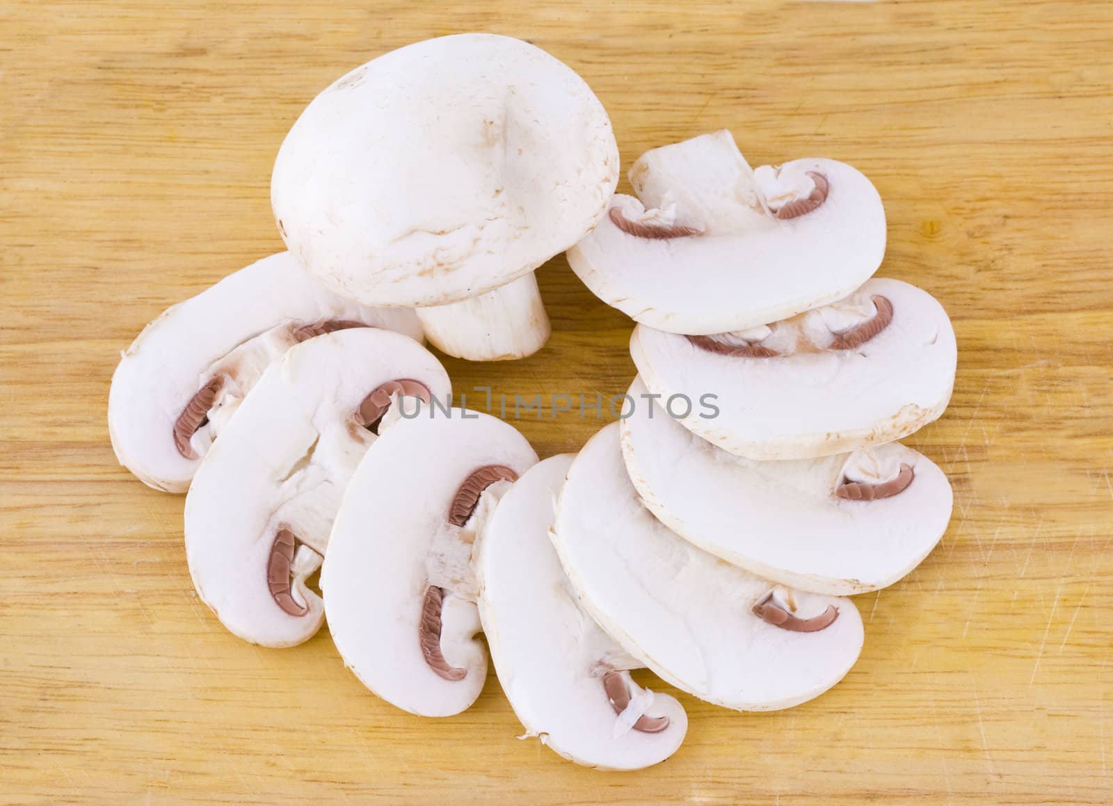Sliced mushrooms on the wooden cutting board background