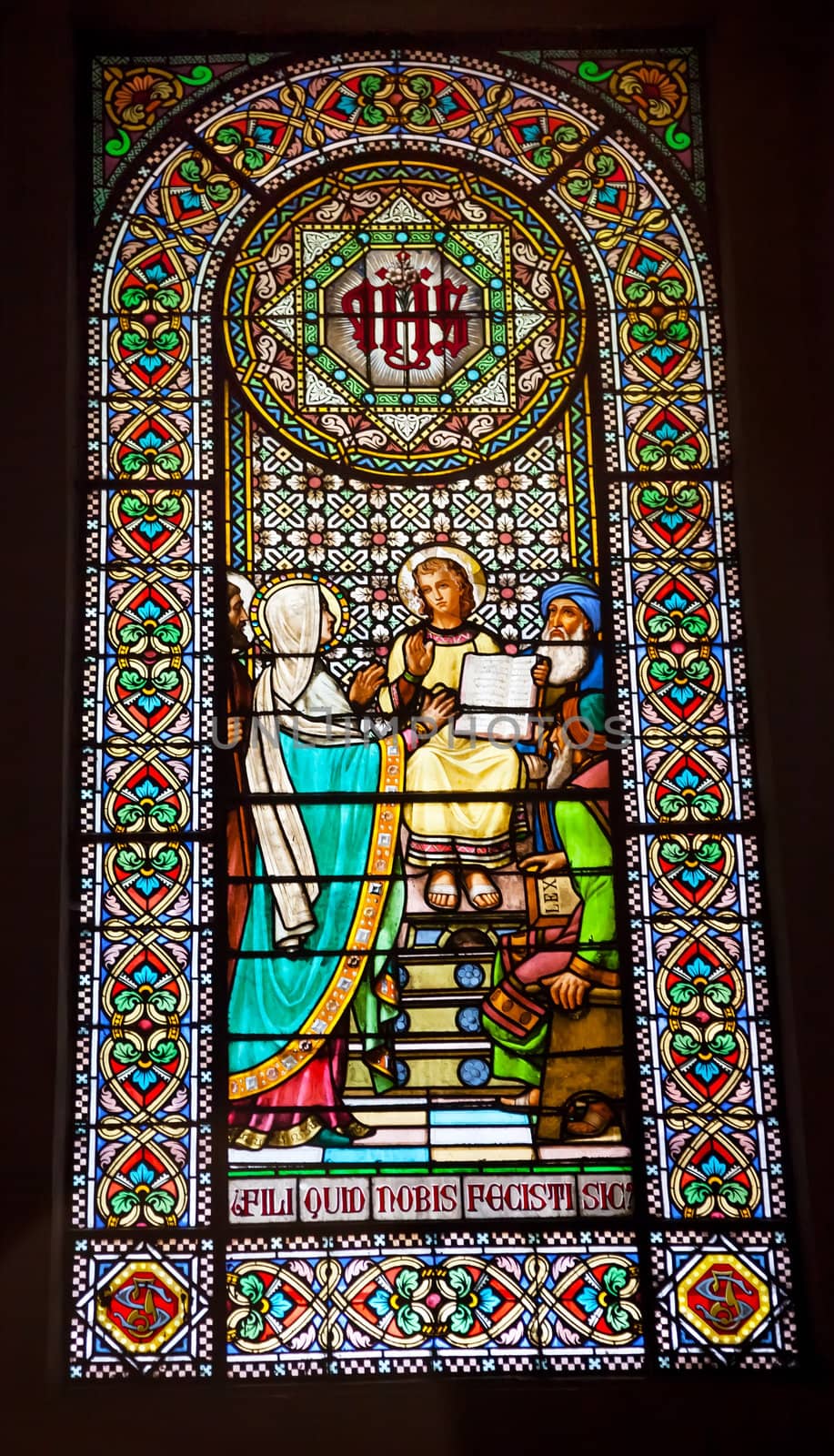 Stained glass window young Jesus teaching temple Mary in basilica inside Monestir Monastery of Montserrat, Barcelona, Catolonia, Spain.  Founded in the 9th century, destroyed in 1811 when French invaded Spain. Rebuilt in 1844 and now a Benedictine monastery.  Placa de Santa Maria.