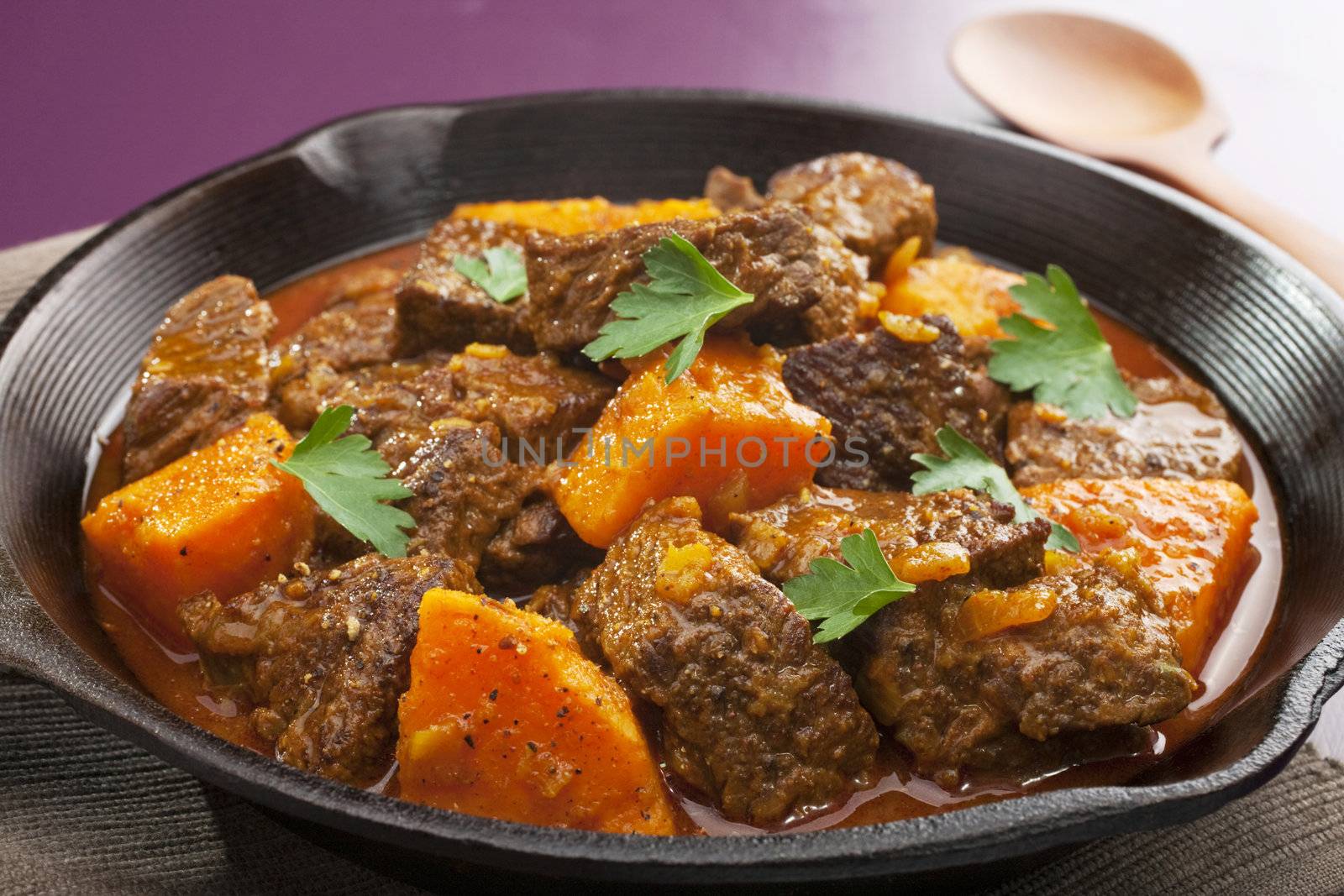 Moroccan tagine or stew of beef with sweet potato, in a cast iron pan.