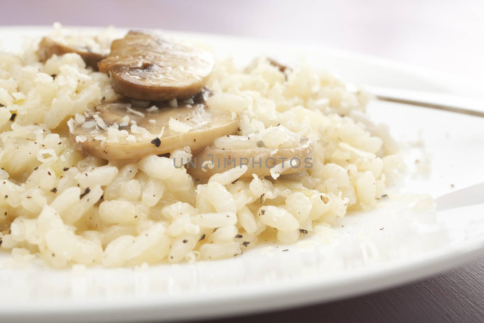 Creamy mushroom risotto sprinkled with black pepper and parmesan.