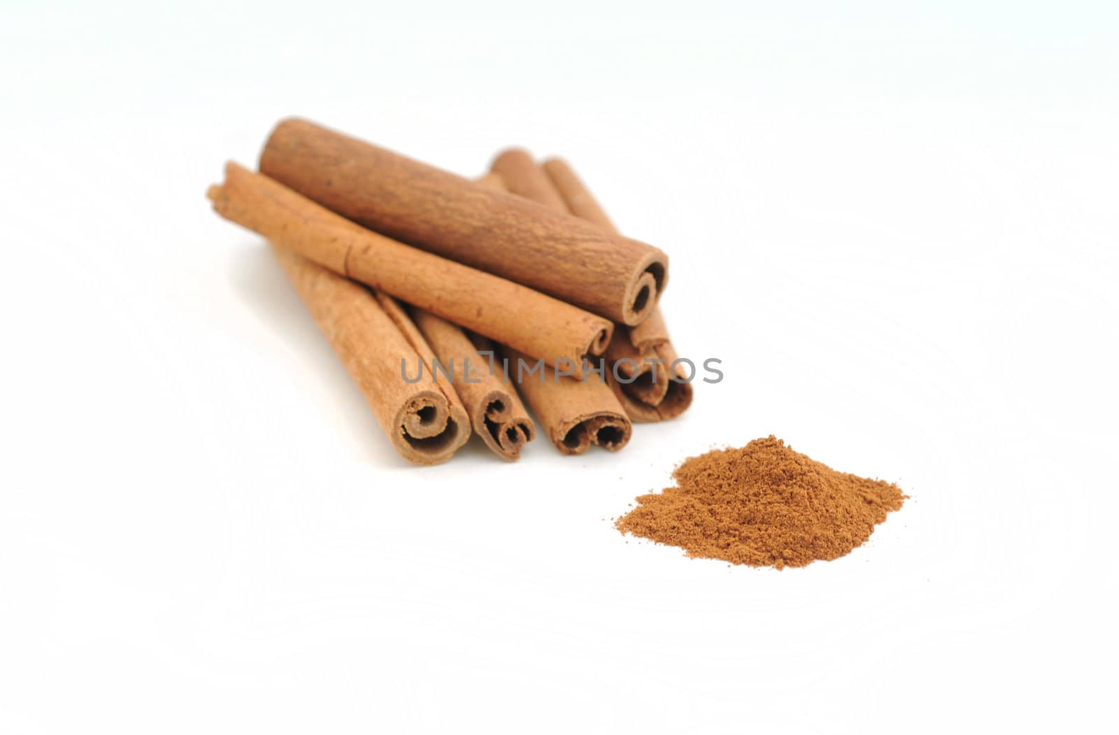 Cinnamon sticks and ground spices on white background