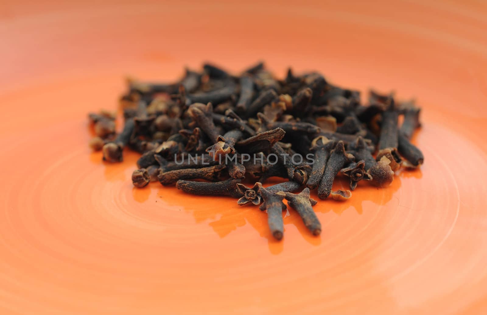 Scented clove spices on orange plate