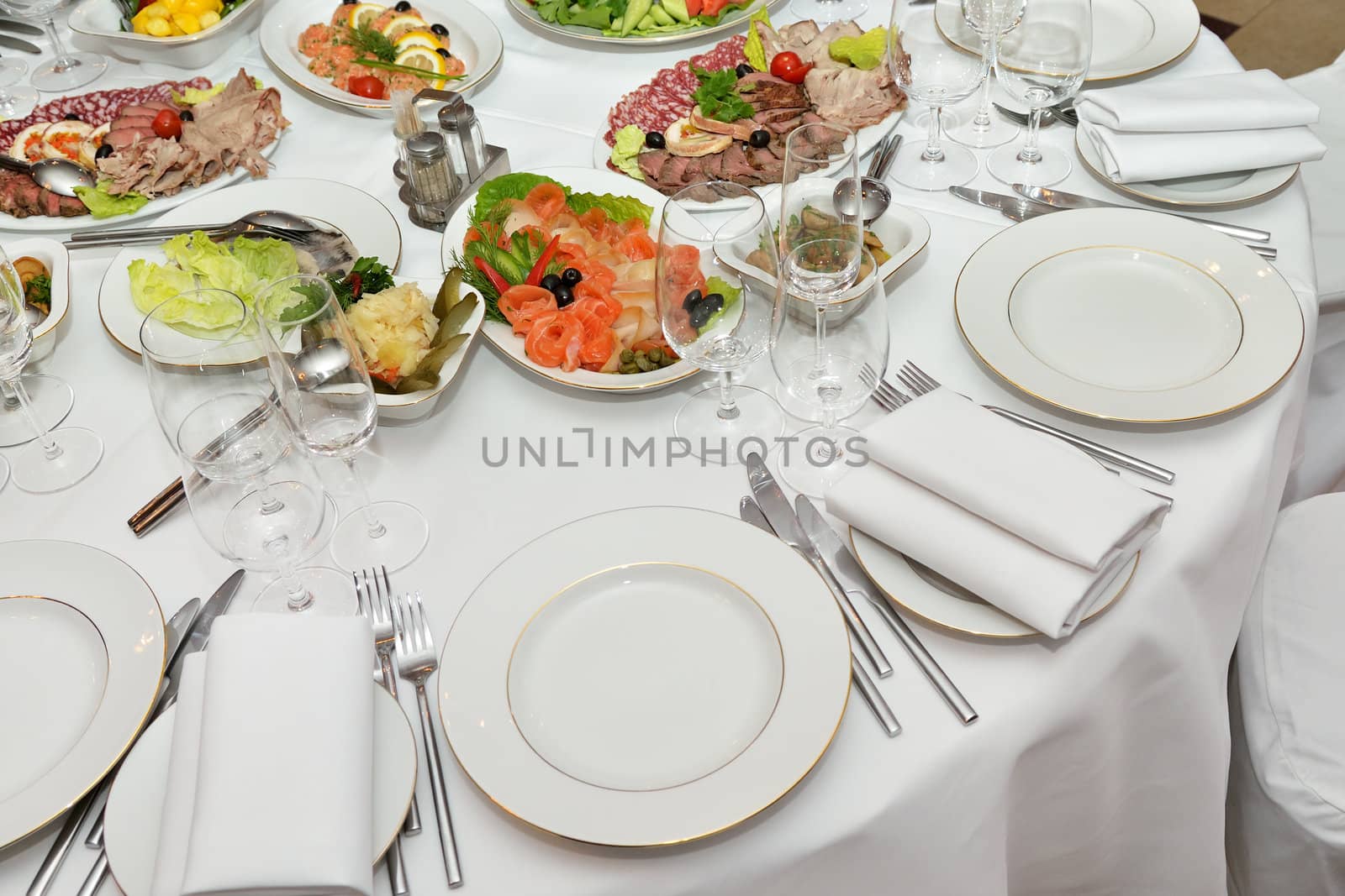 Served table with appetizers, dishes and glasses.