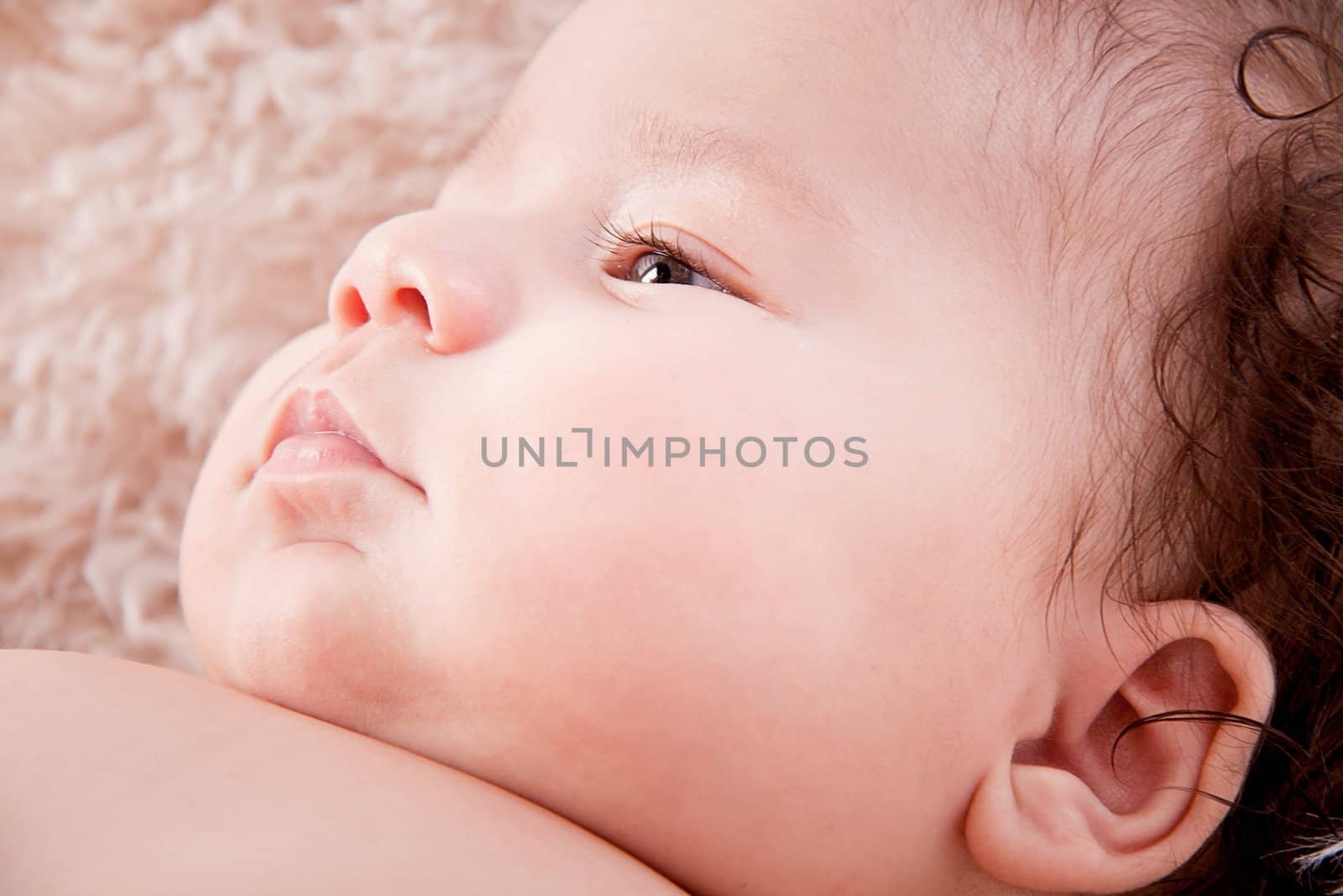 cute little baby infant toddler lying on white blanket smiling portrait