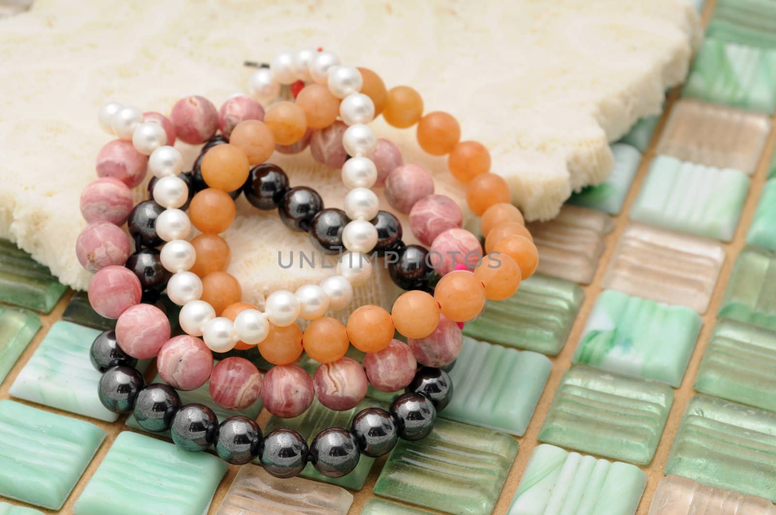 Beaded colorful fashion bracelets on coral and tile background