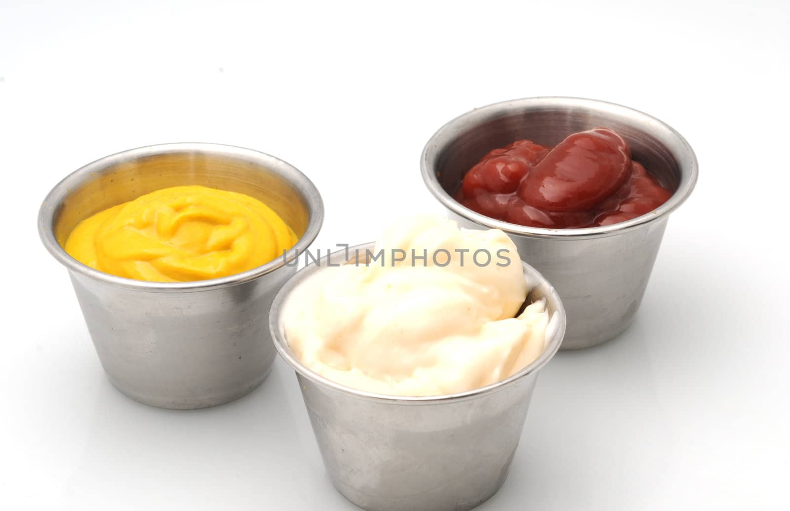 Ketchup, mustard and mayonnaise in small metal bowls