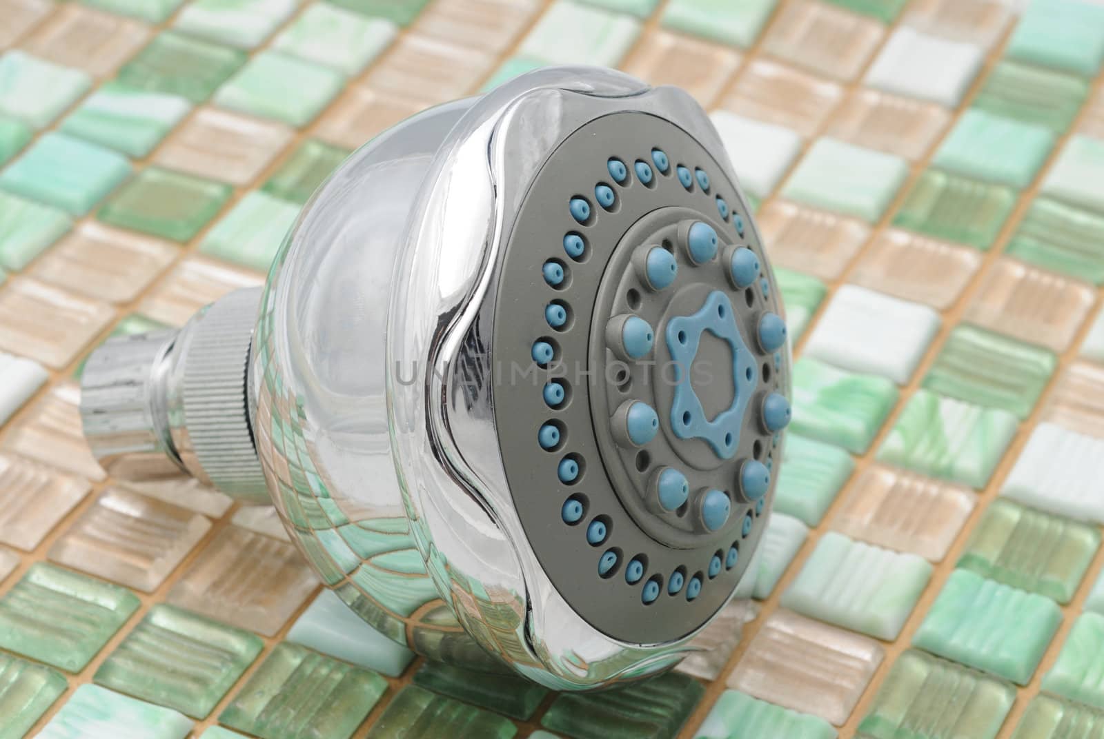 Showerhead on green and white tile background