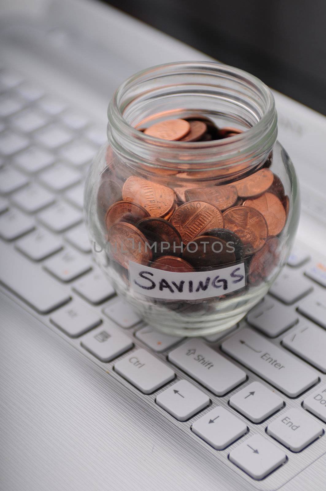 Every penny counts in business savings concept with jar of pennies on a business keyboard