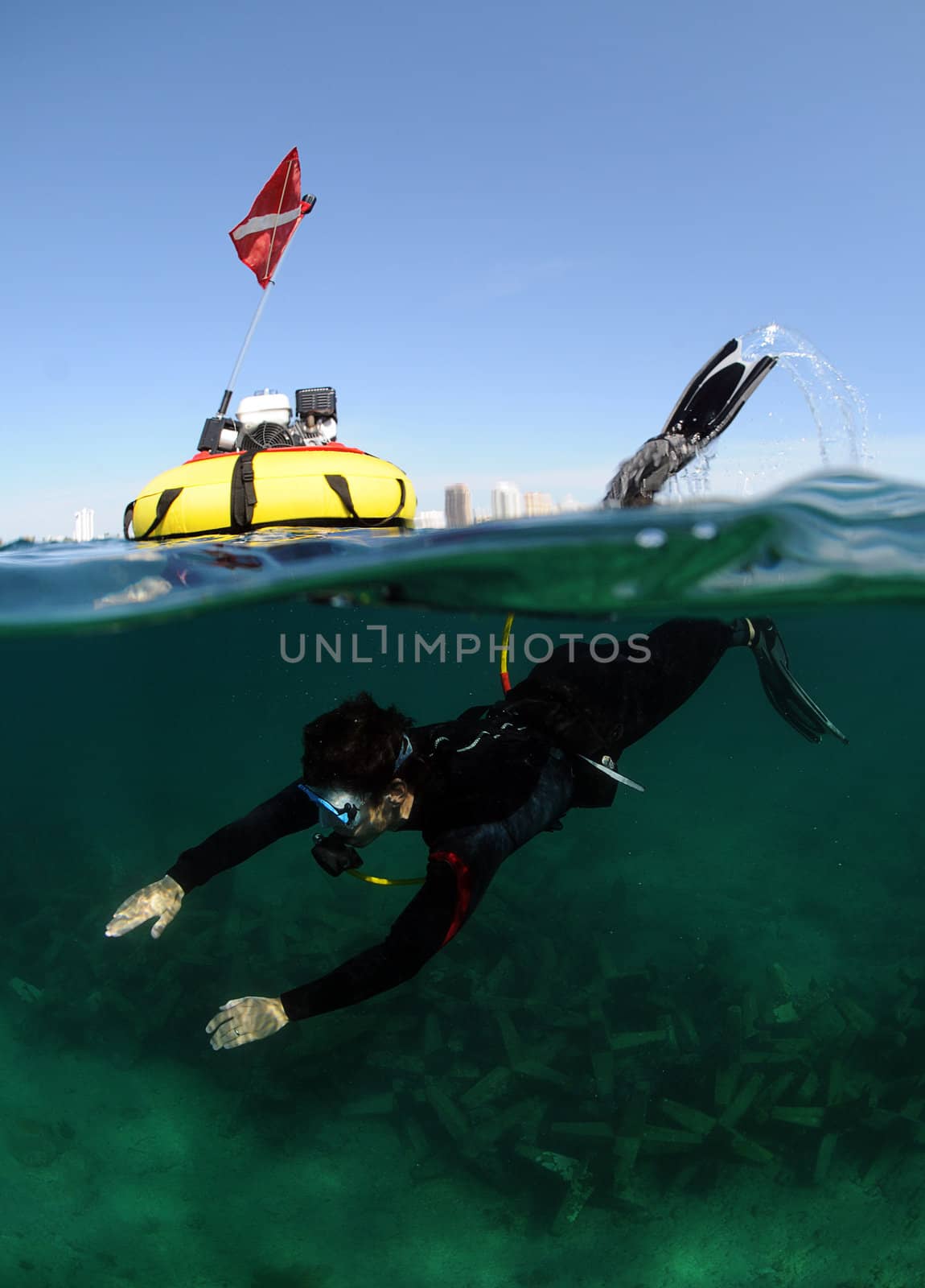 Young man using hookah for diving in ocean with the city of Fort Lauderdale in the background
