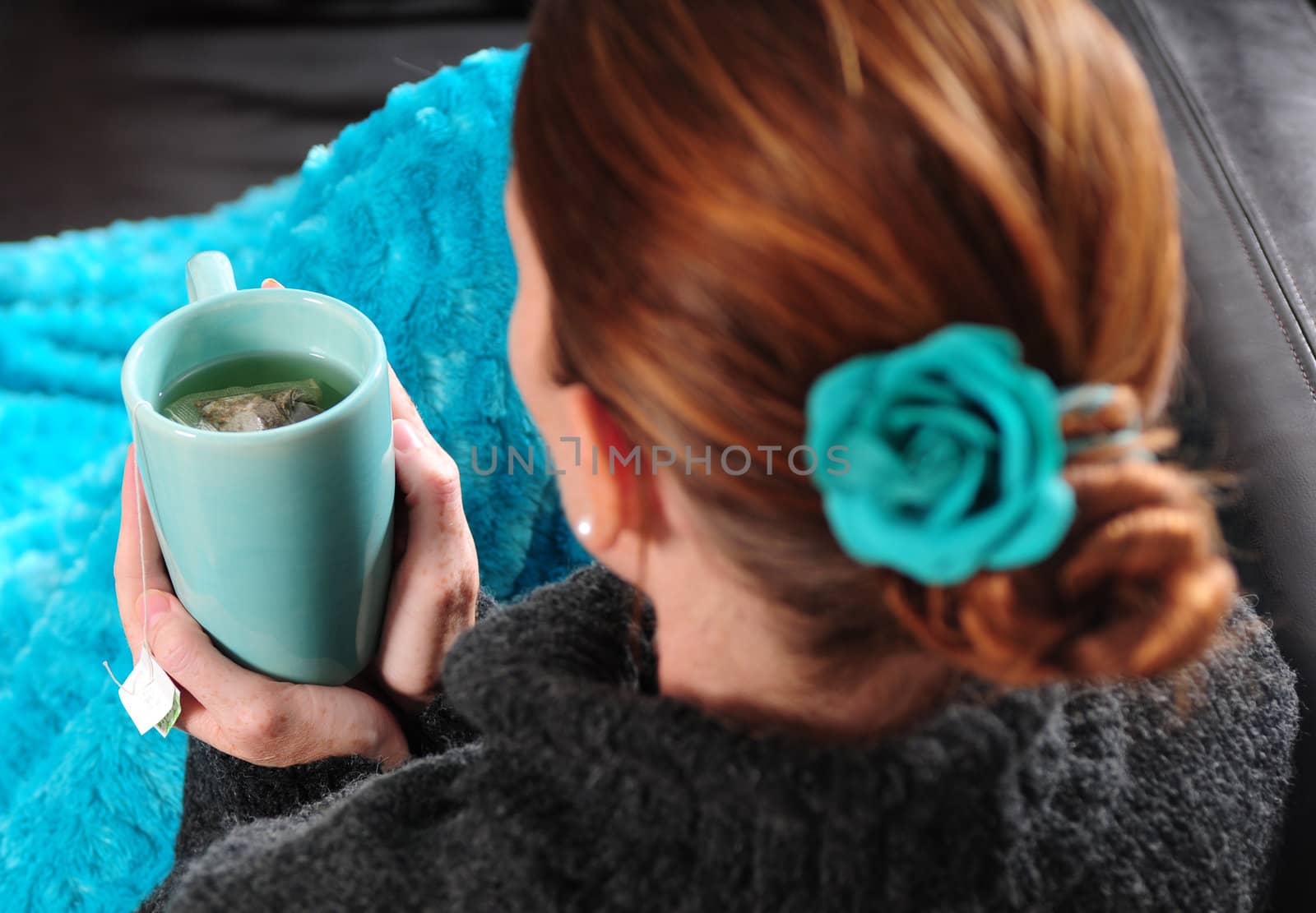 Woman on couch with blanket and cup of tea by ftlaudgirl