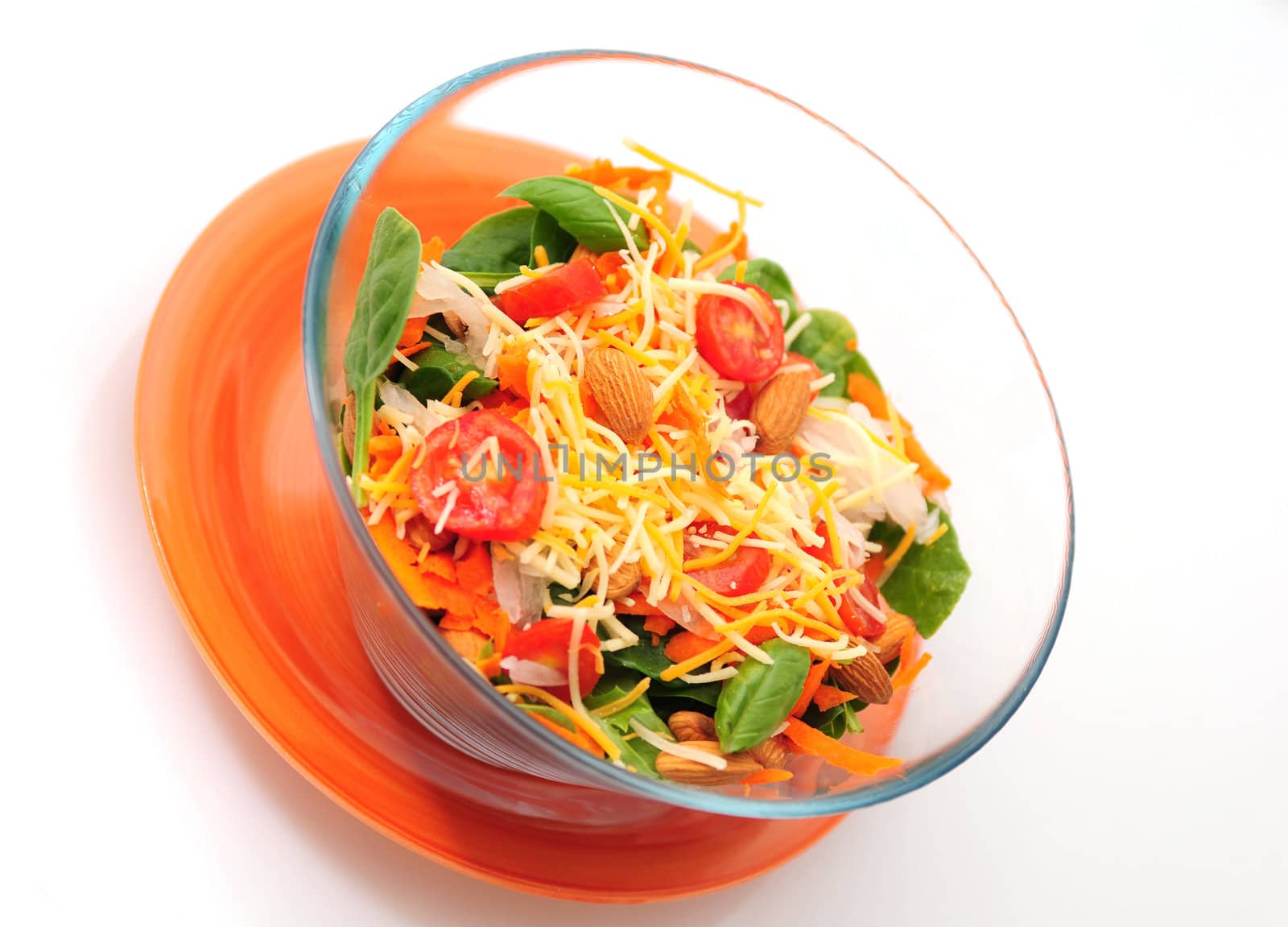 Healthy bowl of salad with greens, veggies and cheese isolated on white