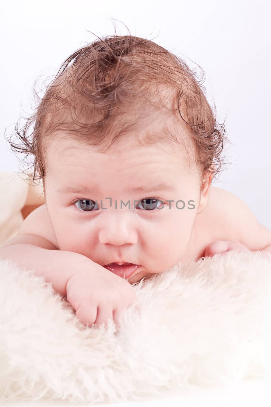 cute little baby infant toddler lying on white blanket smiling portrait