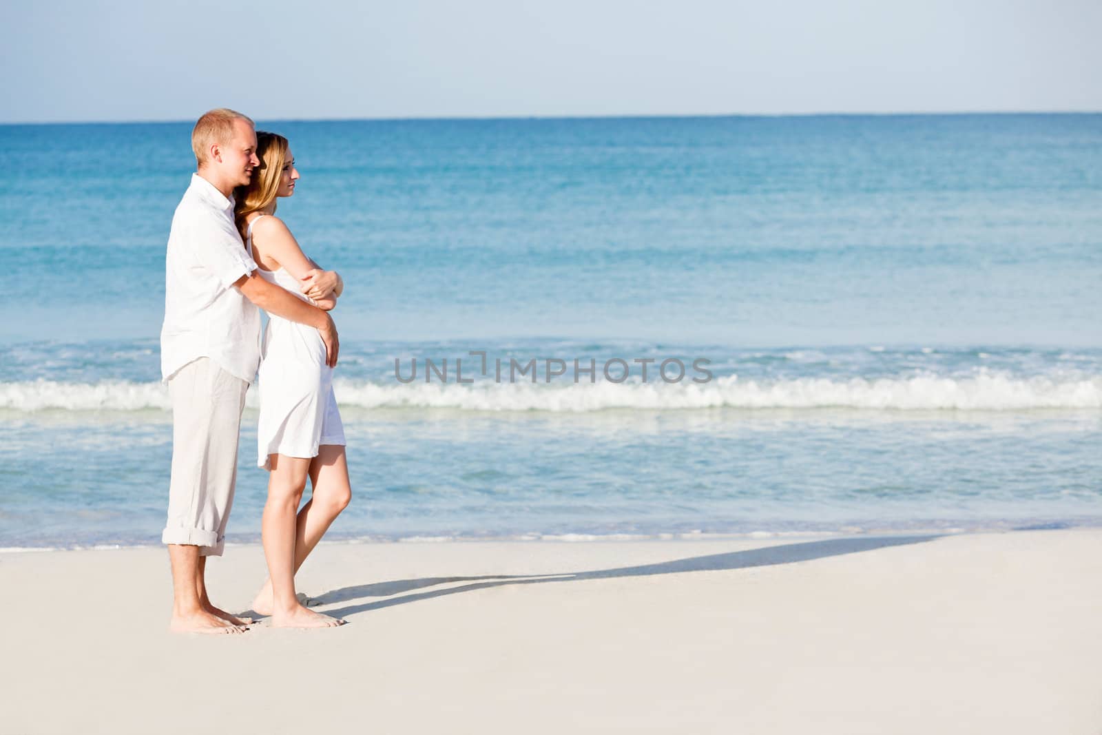 happy young couple in love having fun on the beach blue sky and sunshine 