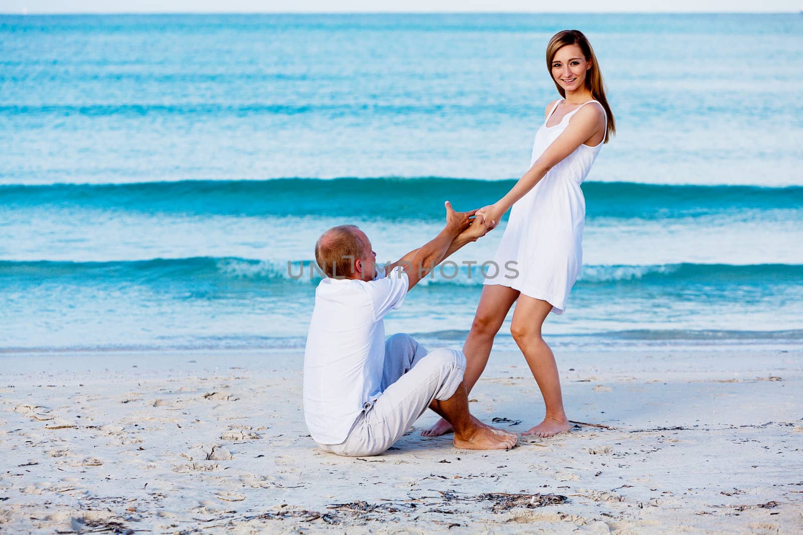 happy young couple in love having fun on the beach blue sky and sunshine 