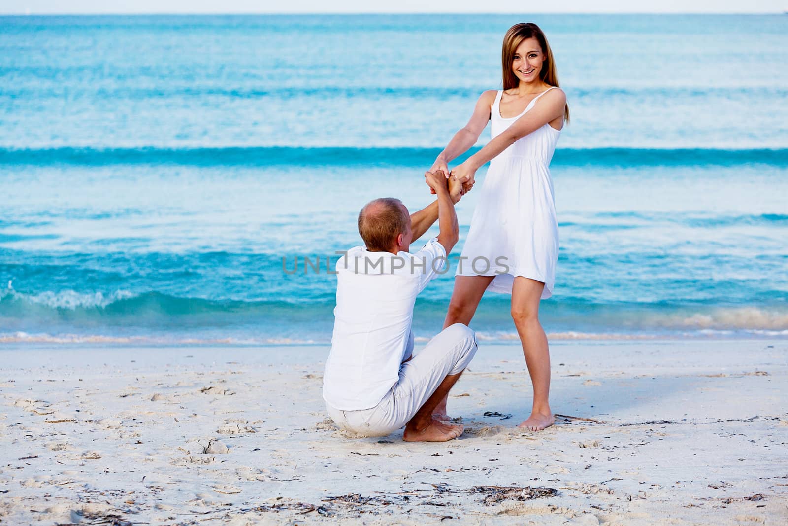 happy young couple in love having fun on the beach blue sky and sunshine 