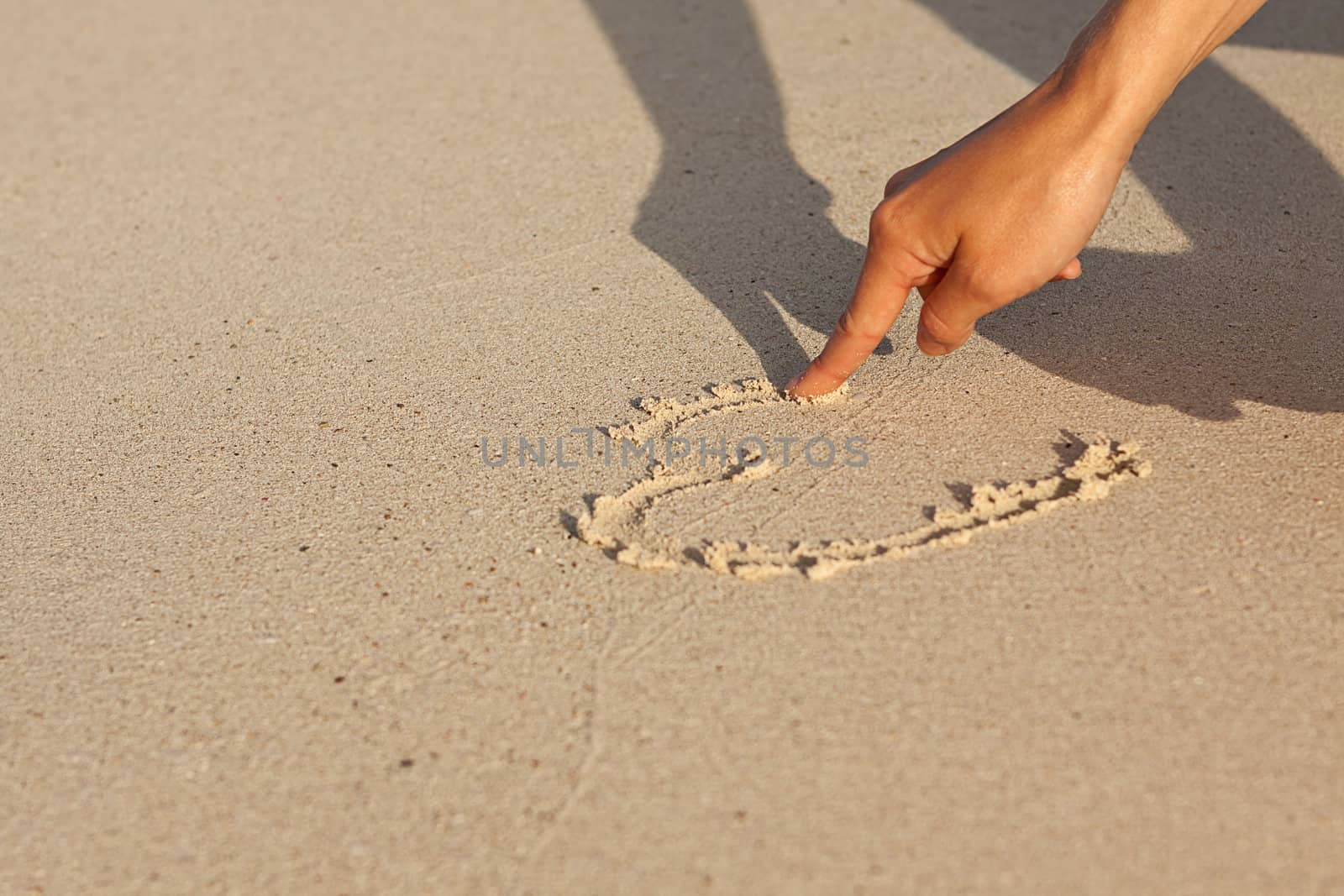 hand writing in sand in summer holiday vacation on beach 