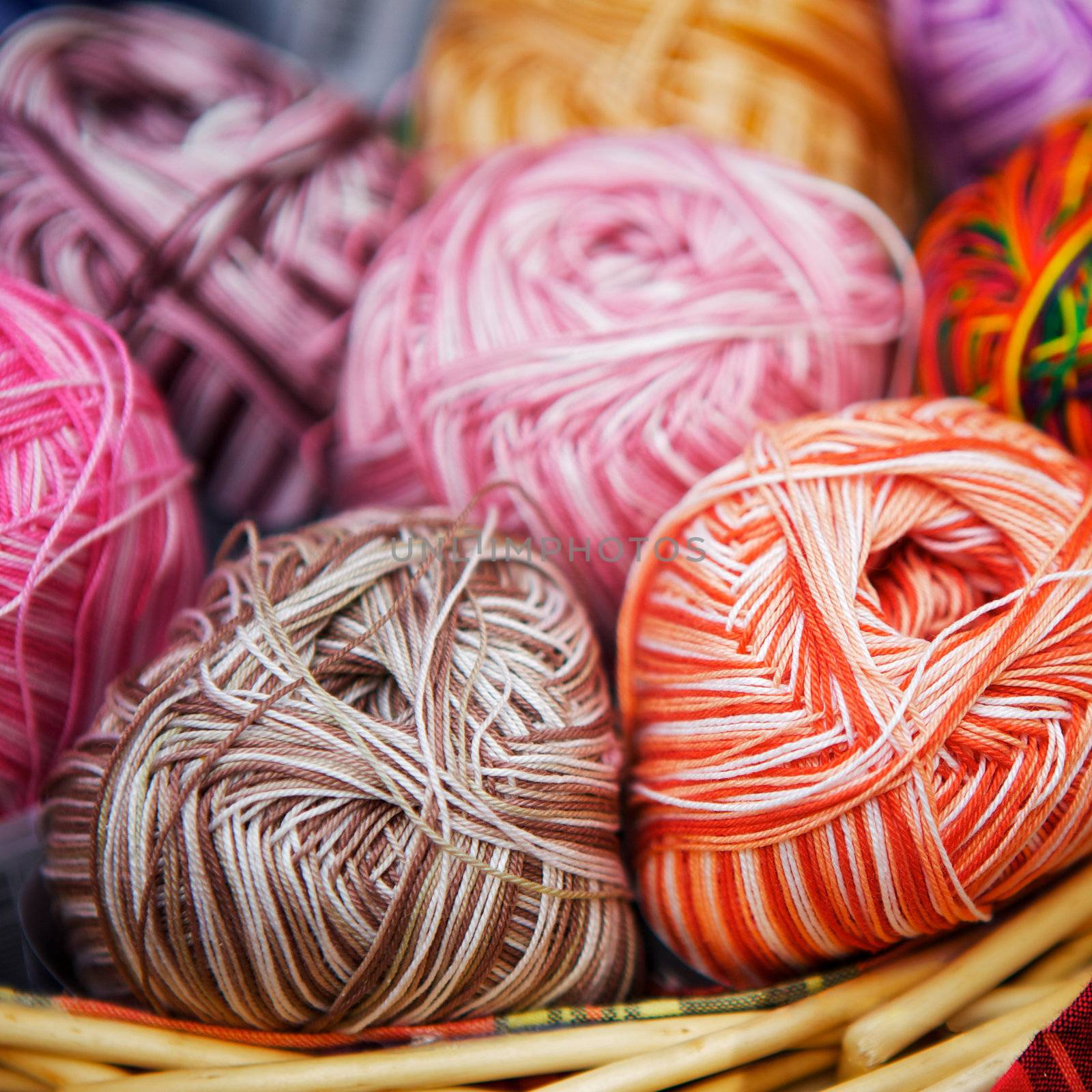 balls of knitted wool in basket, closeup