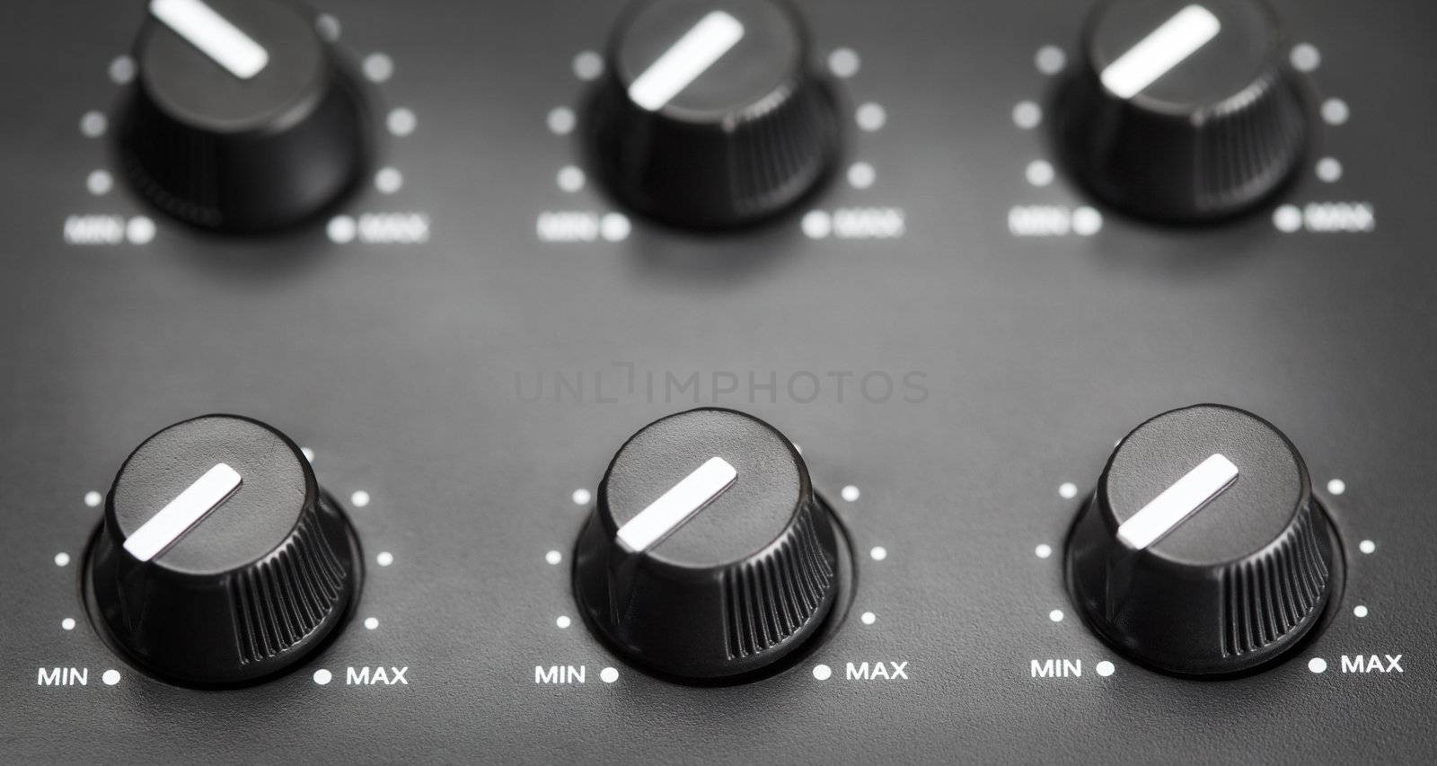 volume knobs with calibration on plastic plate, closeup