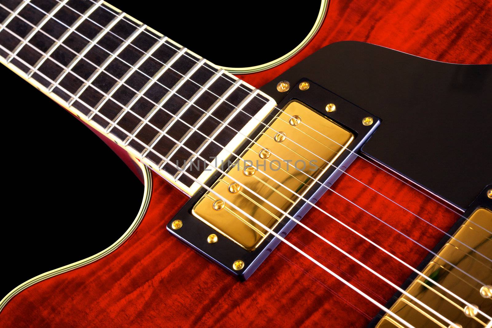 red electric guitar isolated on black background, closeup