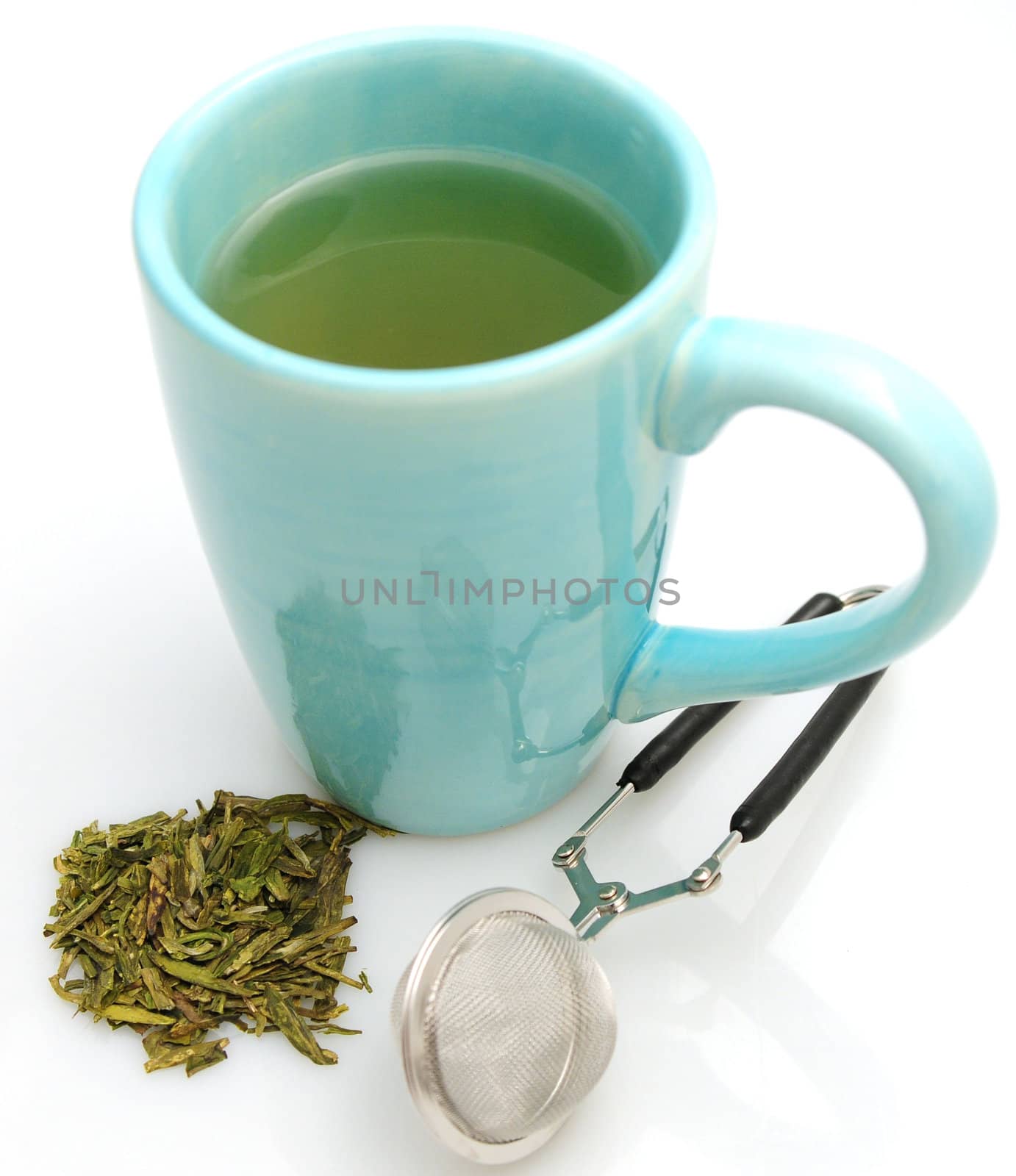 Green tea and infuser on white by ftlaudgirl