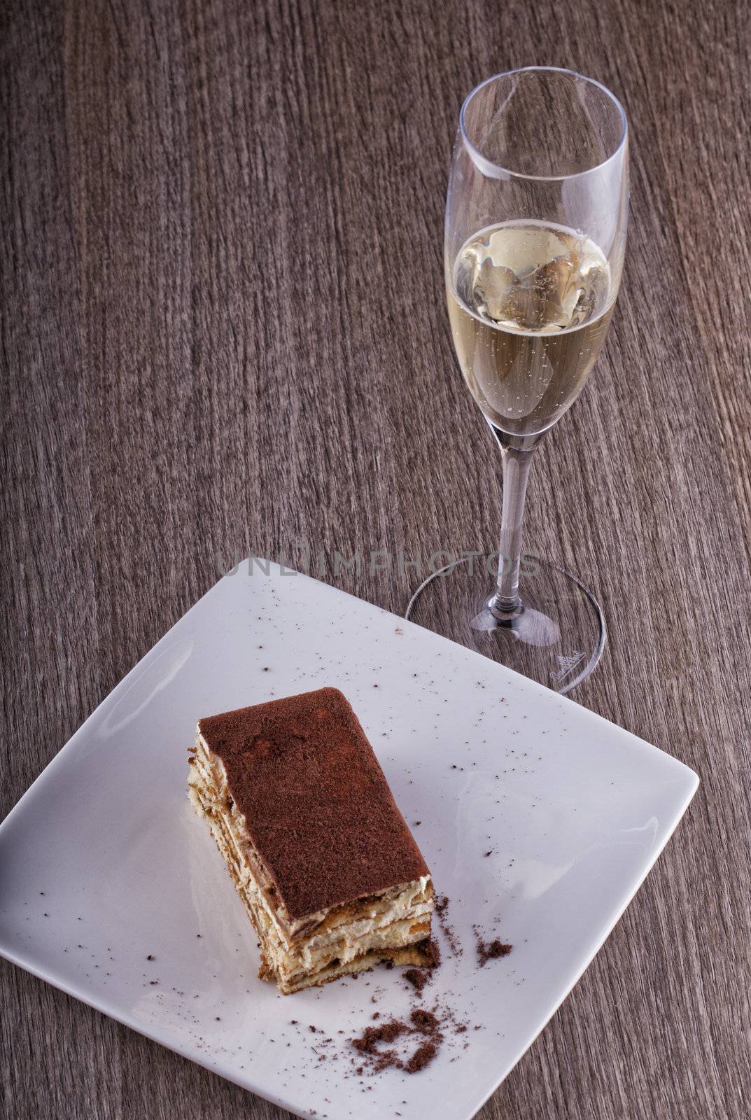 A slice of cake and a flute of white wine