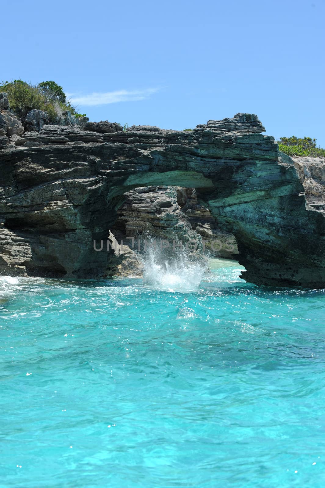 Rocks in shape of arch in the Bahamas with clear blue ocean water