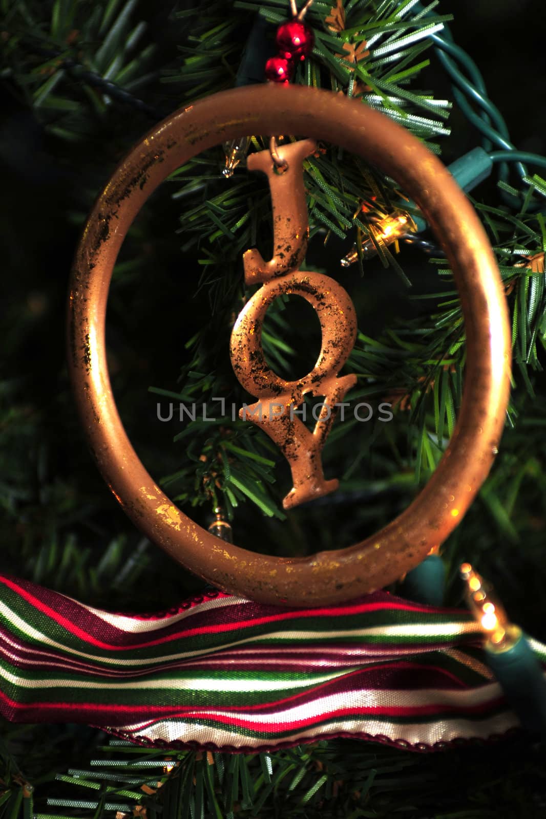 Gold Christmas decoration with the word joy on a Christmas tree