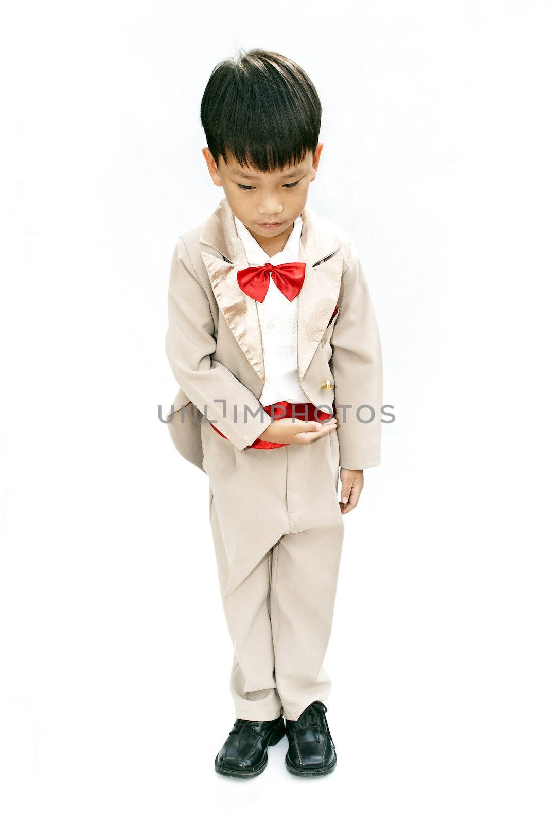 Little boy with brown tuxedo and red bow tie on white background