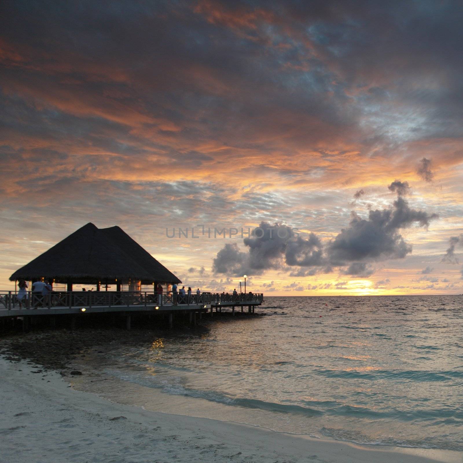 Beach and tropical resort hotel of Maldives on sunset