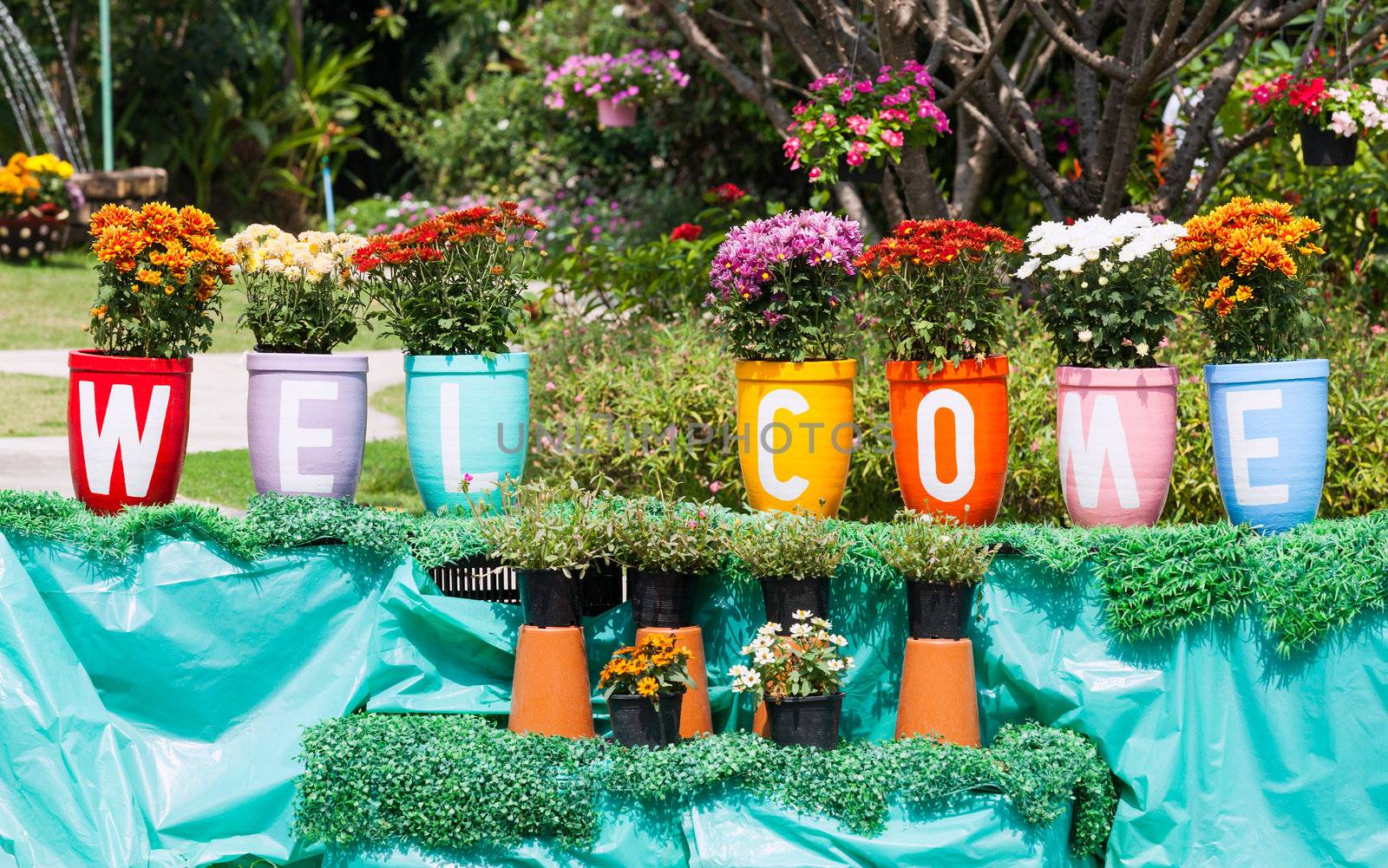 Flower clay pot and painting that welcome message in the garden.