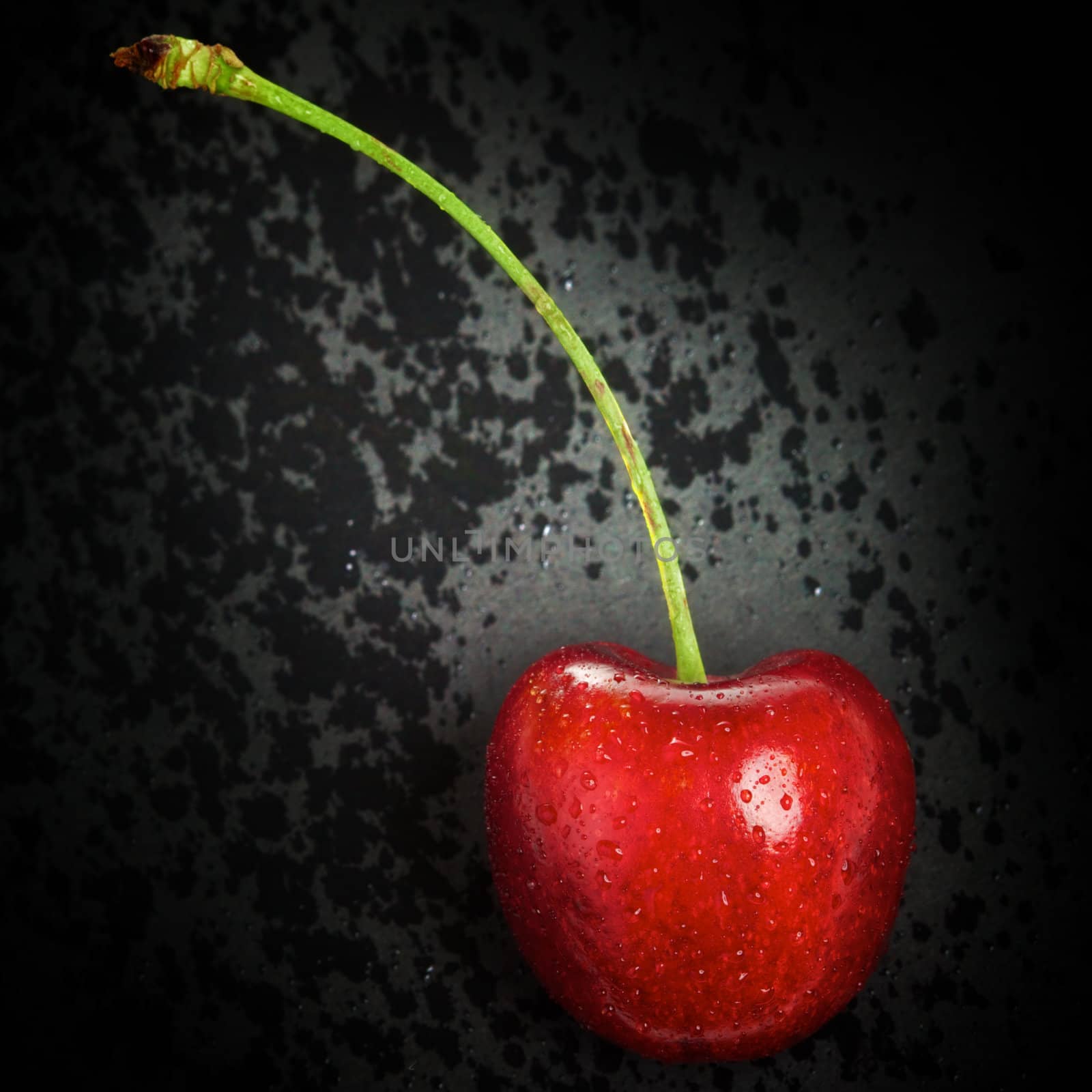 fresh red cherry lying on black background