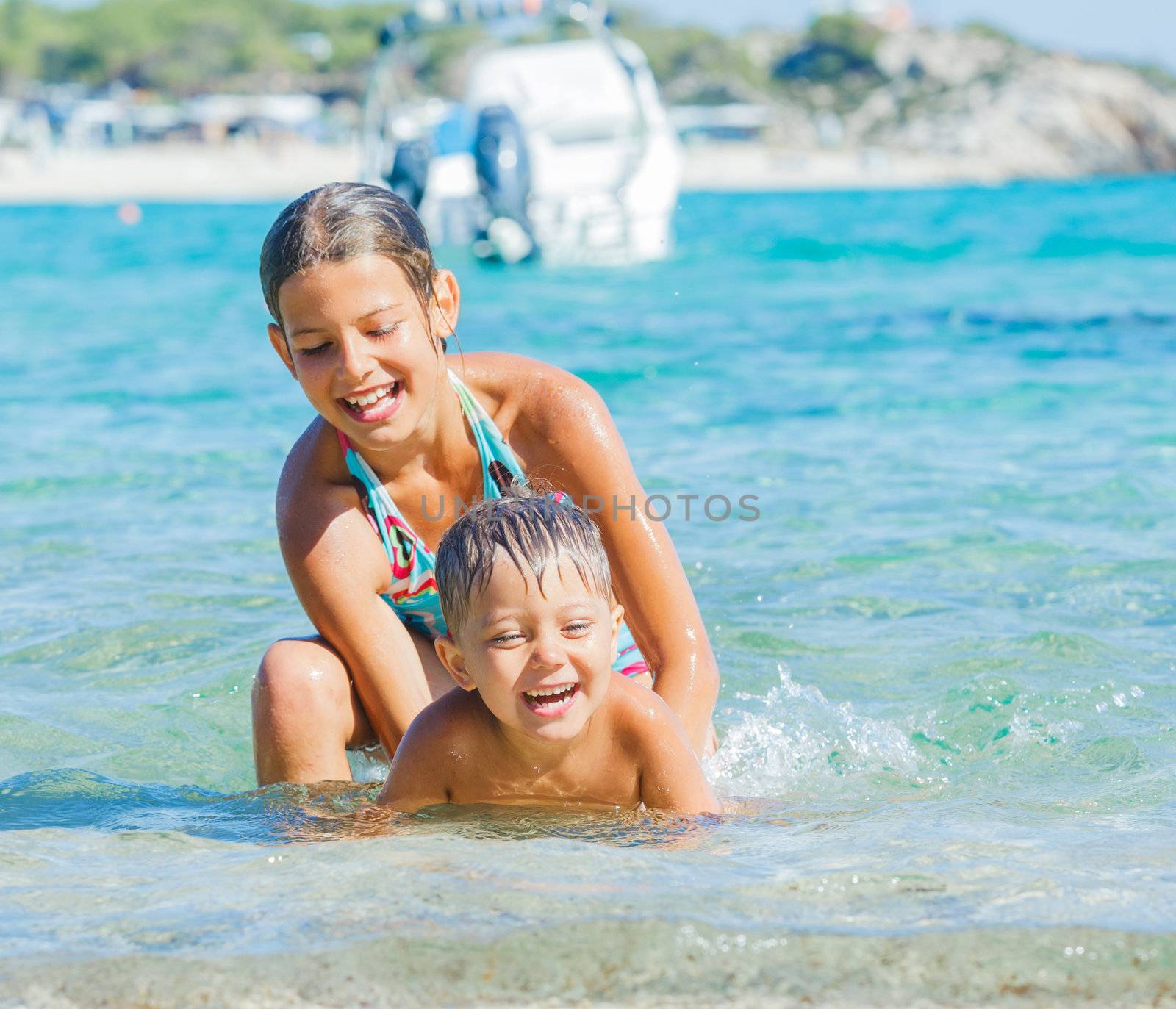 Happy kids. Sister and brother playing and swimming in the transparent sea