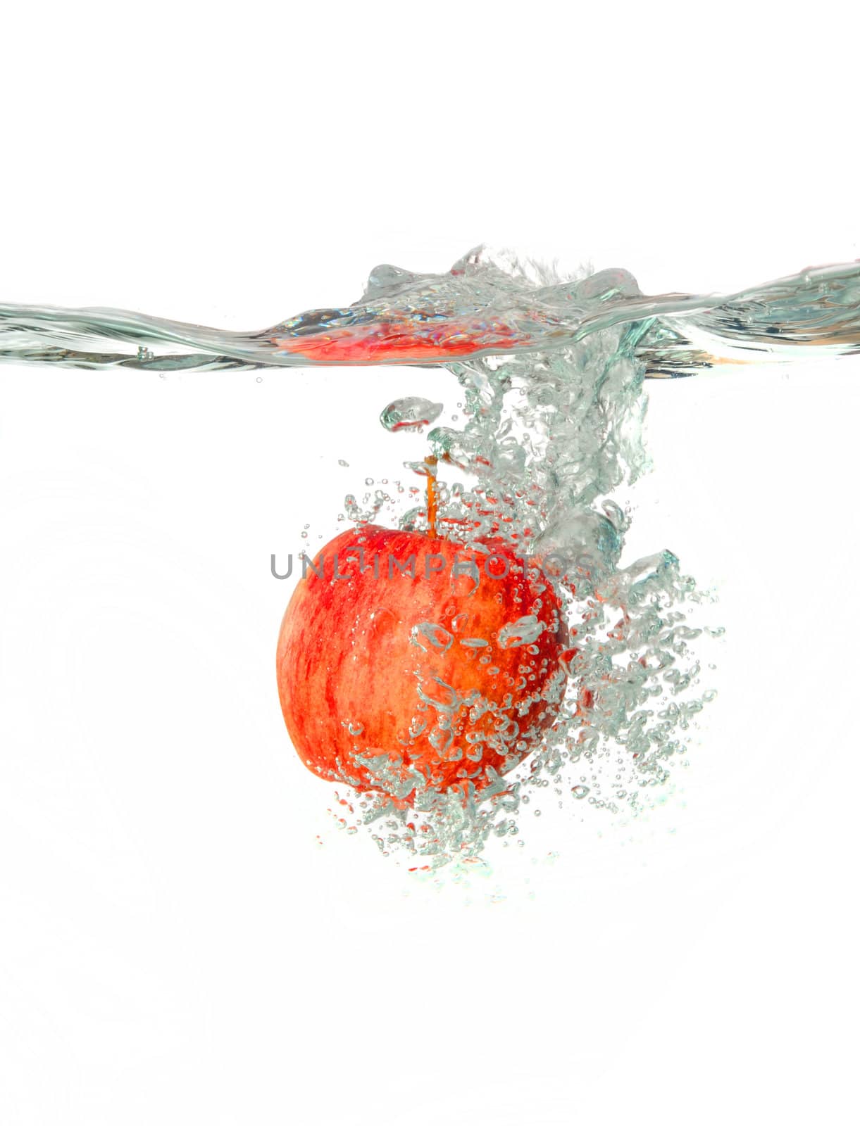 red apple Making a splash while falling into clear water