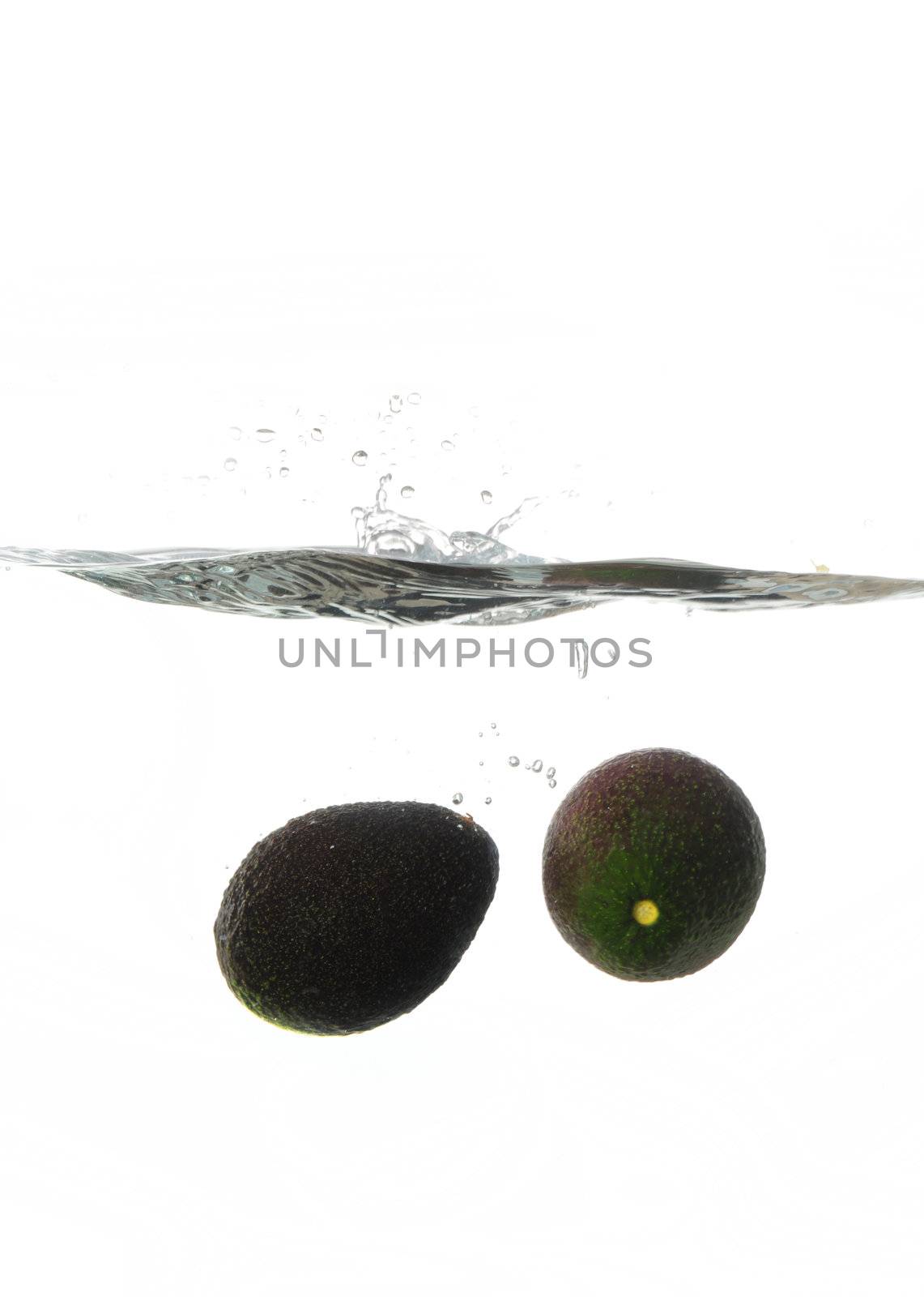 Avocadoes Making a splash while falling into clear water