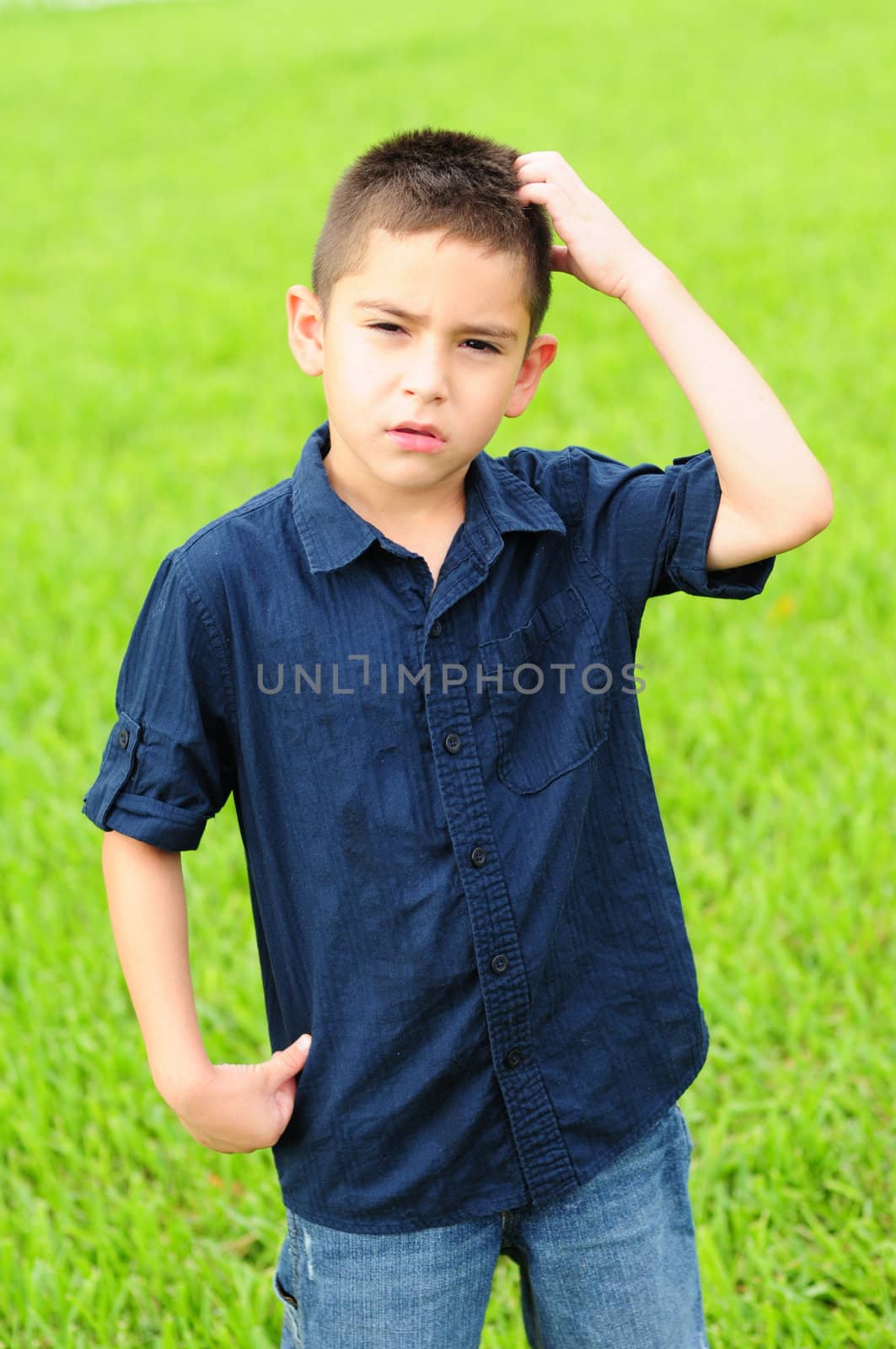 Cute young boy scratching his head in confusion