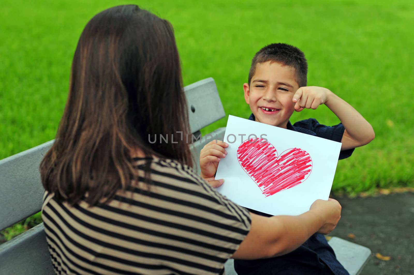 Boy giving his mom a heart drawing for a present