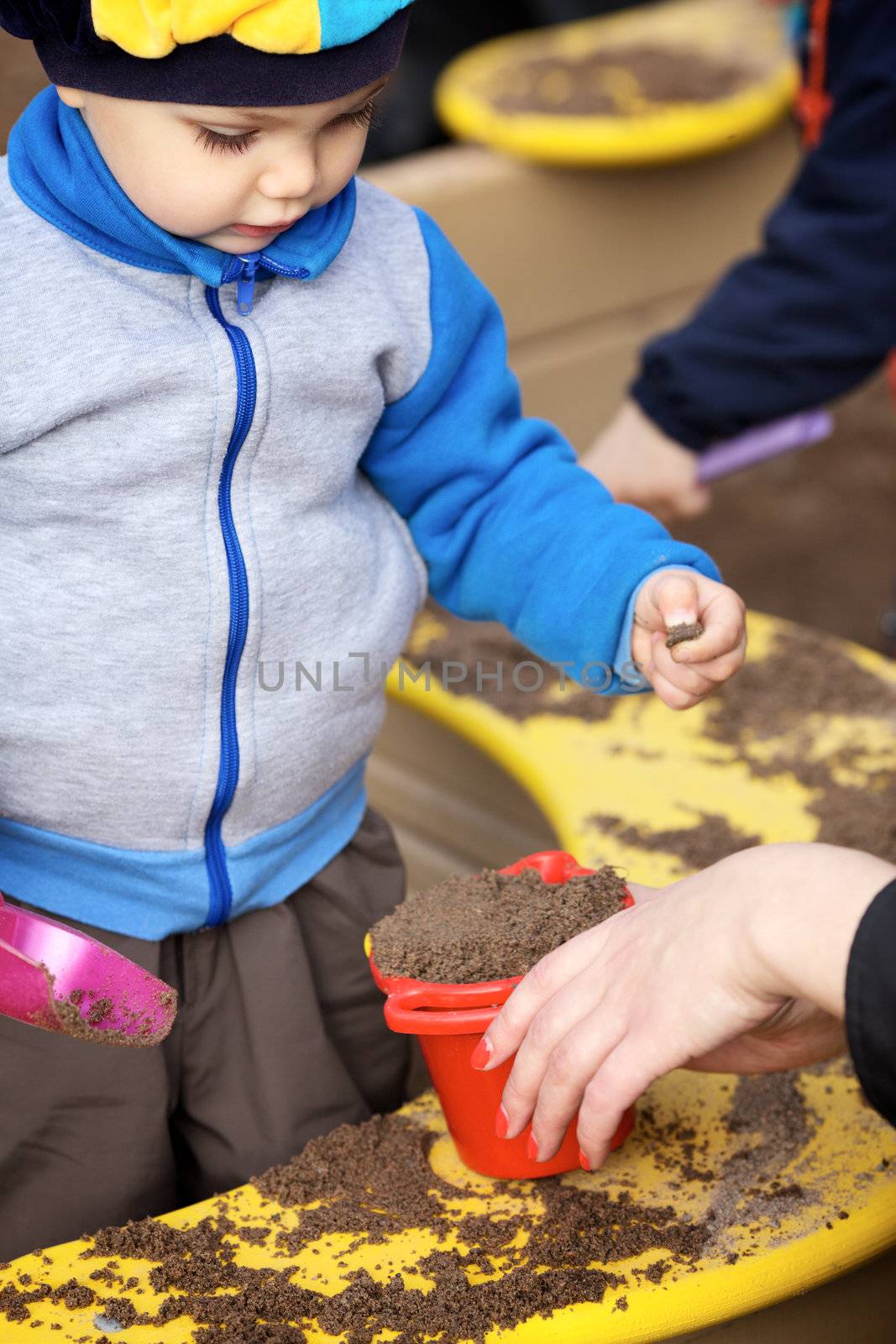 Boy Playing in Sandbox by petr_malyshev