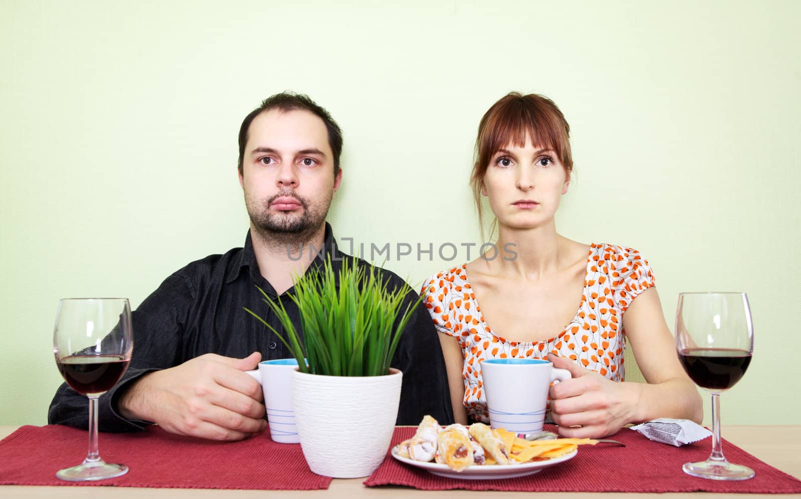 strange couple at the table drink tea and looking nowhere