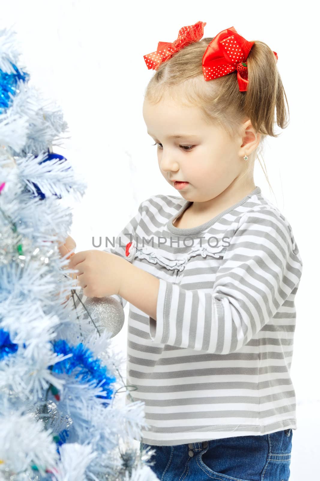 beautiful happy small girl decorate christmas tree