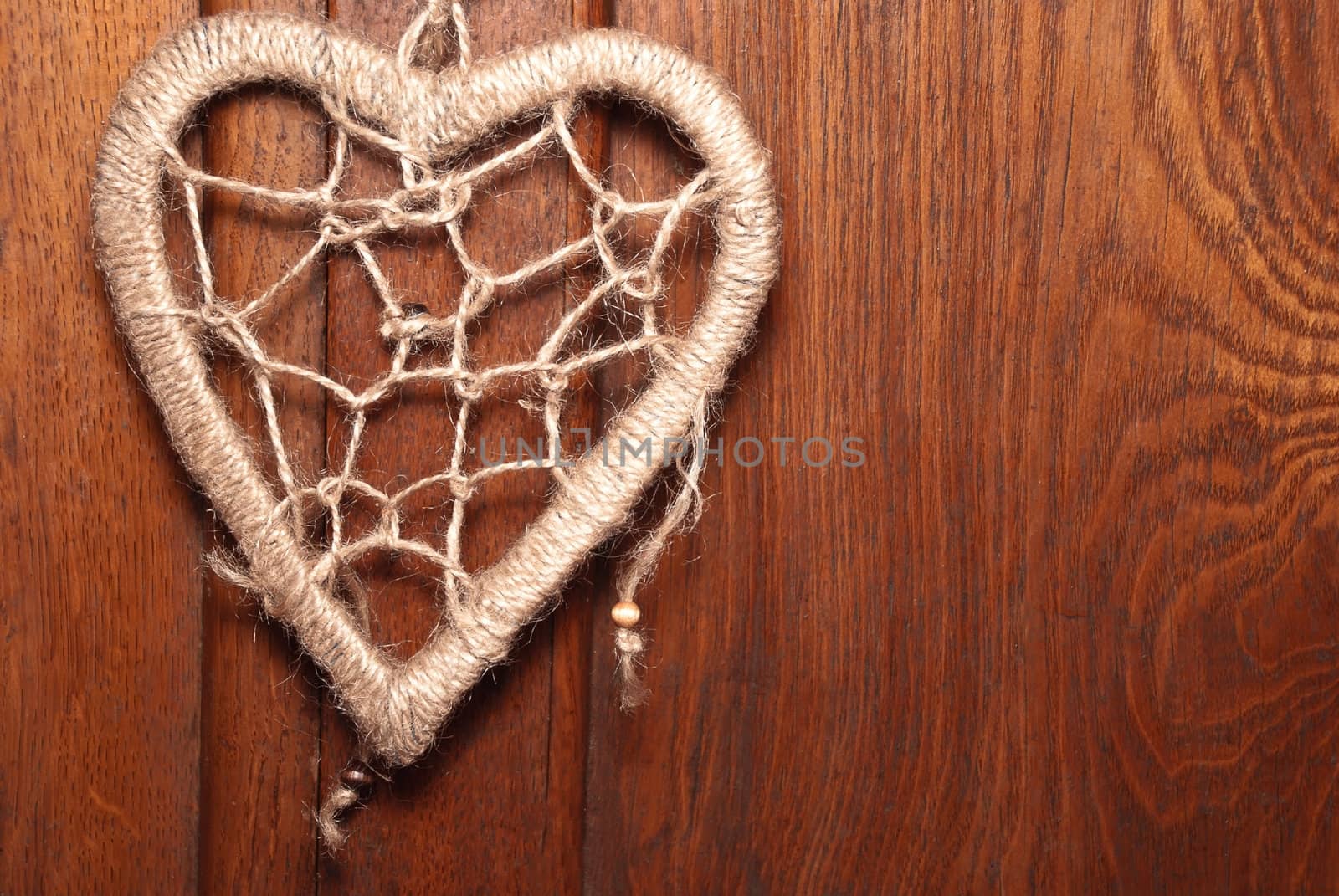 Rope heart on the old wood background.