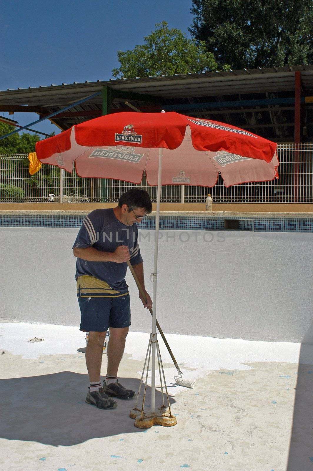 painter painting the bottom of a swimming pool                                